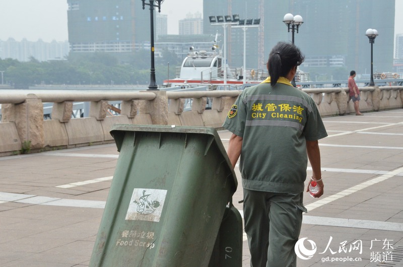 环卫工熟悉的背影,每天拉着垃圾桶清理着城市环境卫生.林龙勇 摄