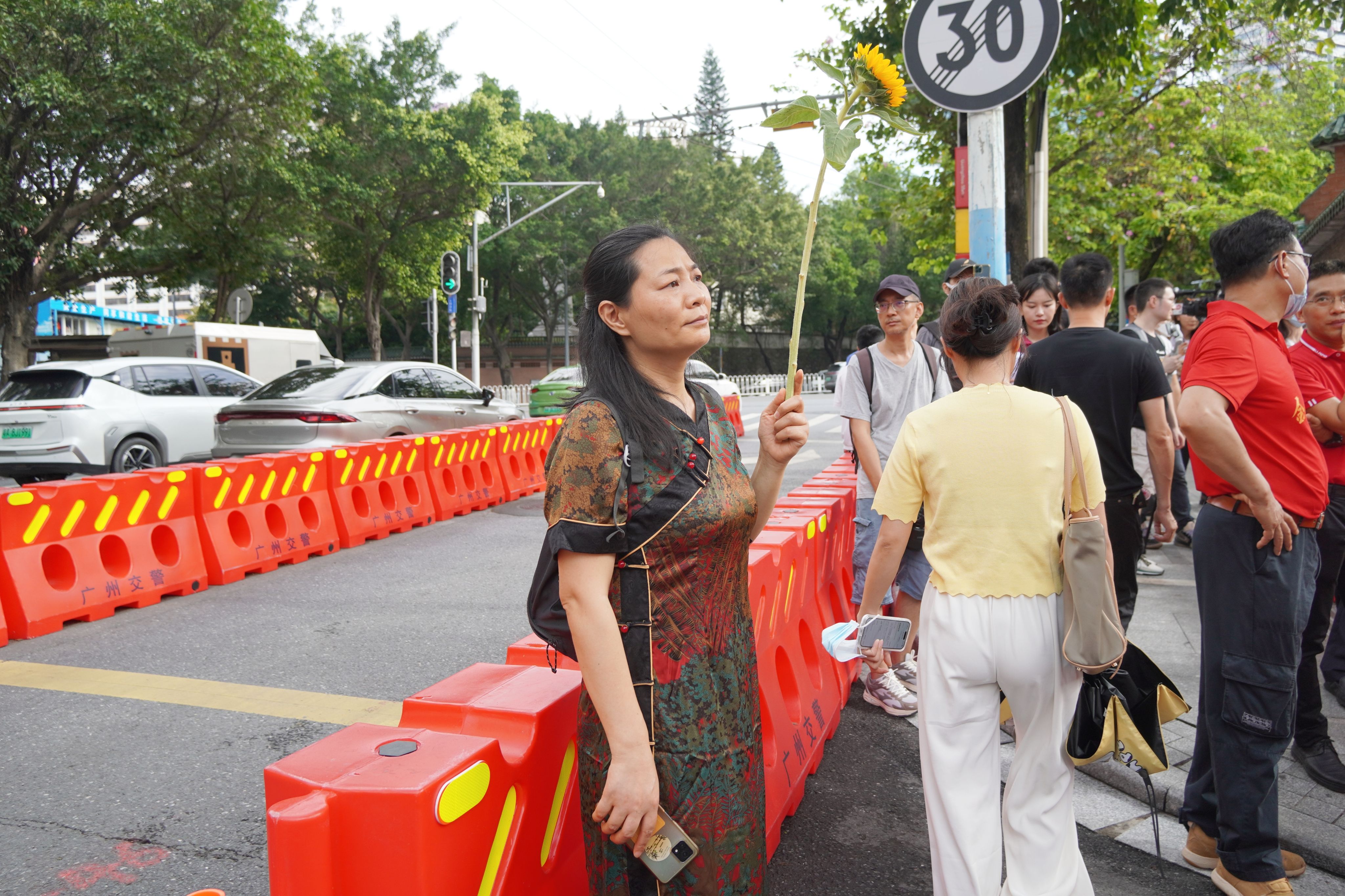 在廣東省廣州市高考考點，一位母親手捧寓意祝福的向日葵等待考生。王雅蝶 攝