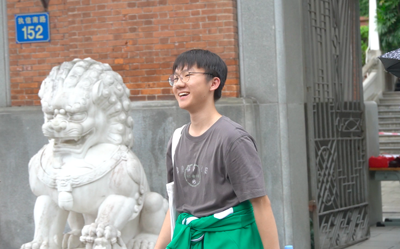 高考语文结束后，一位广东考生面带笑容走向考场外的亲友。王雅蝶 摄
