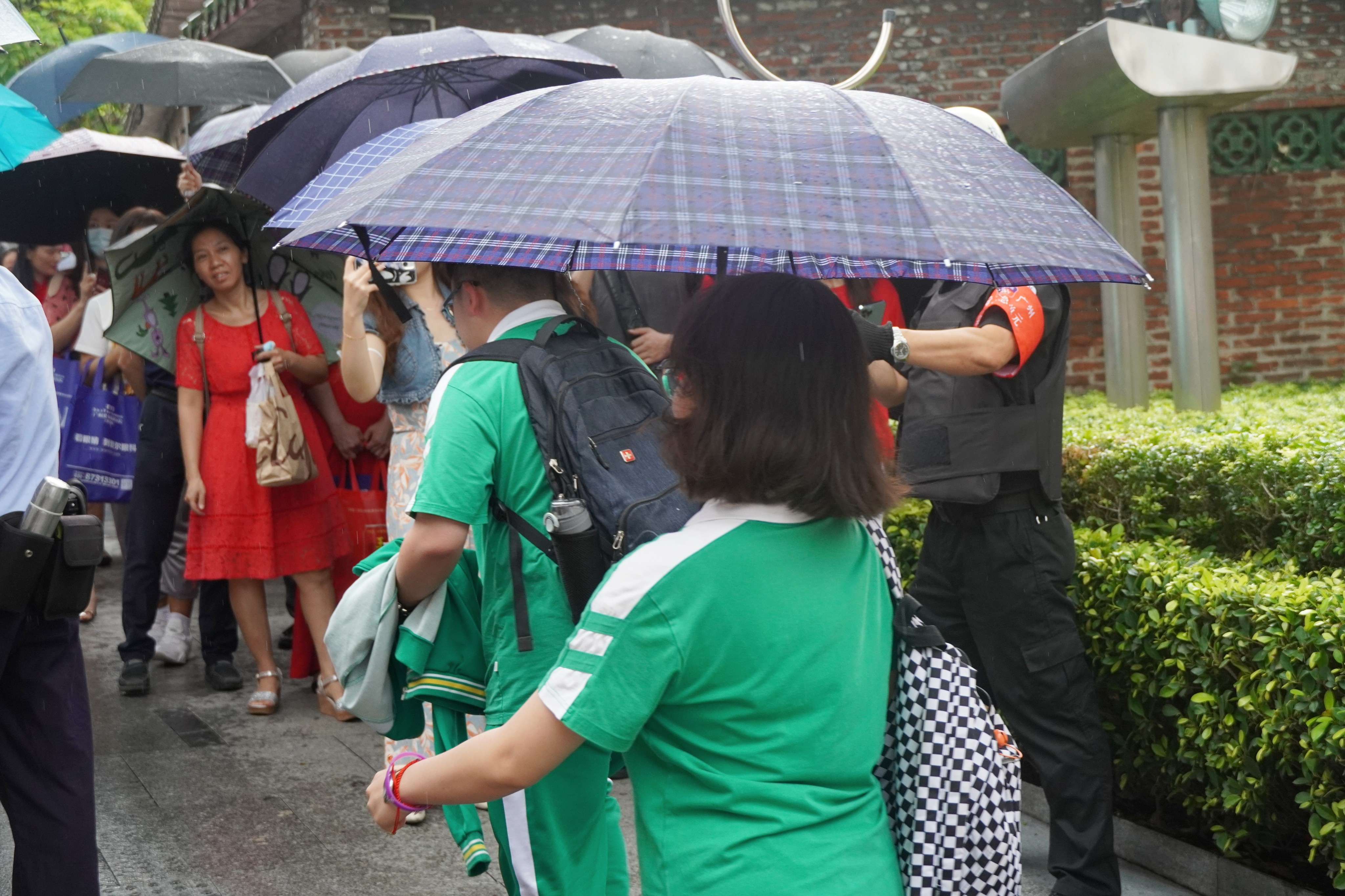高考首日，在广东省广州市一高考考点，考生陪考家属冒雨等待孩子。王雅蝶 摄