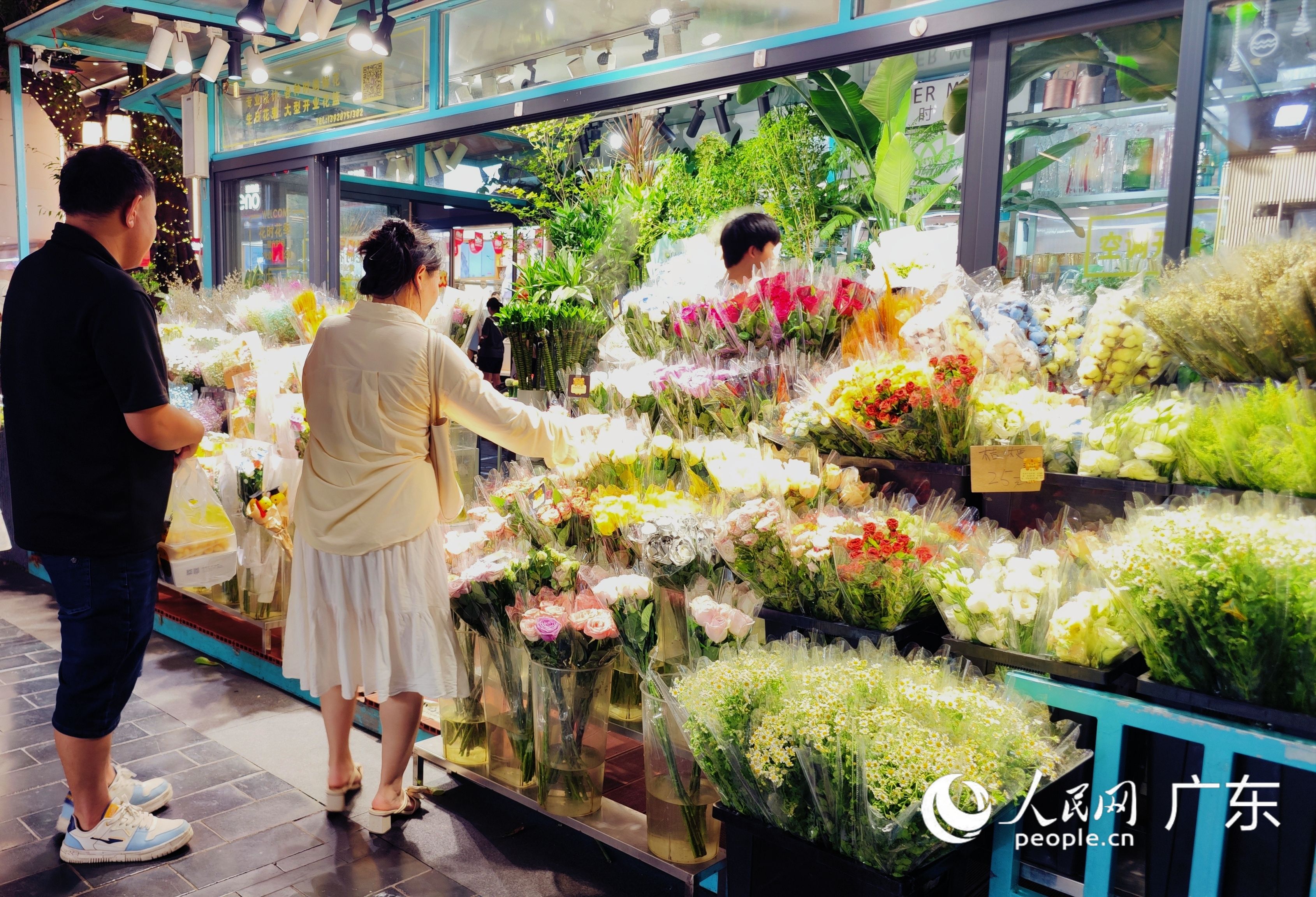 北京路历史文化街区的花市直销花店，情侣共同选购鲜花。人民网 朴馨语摄