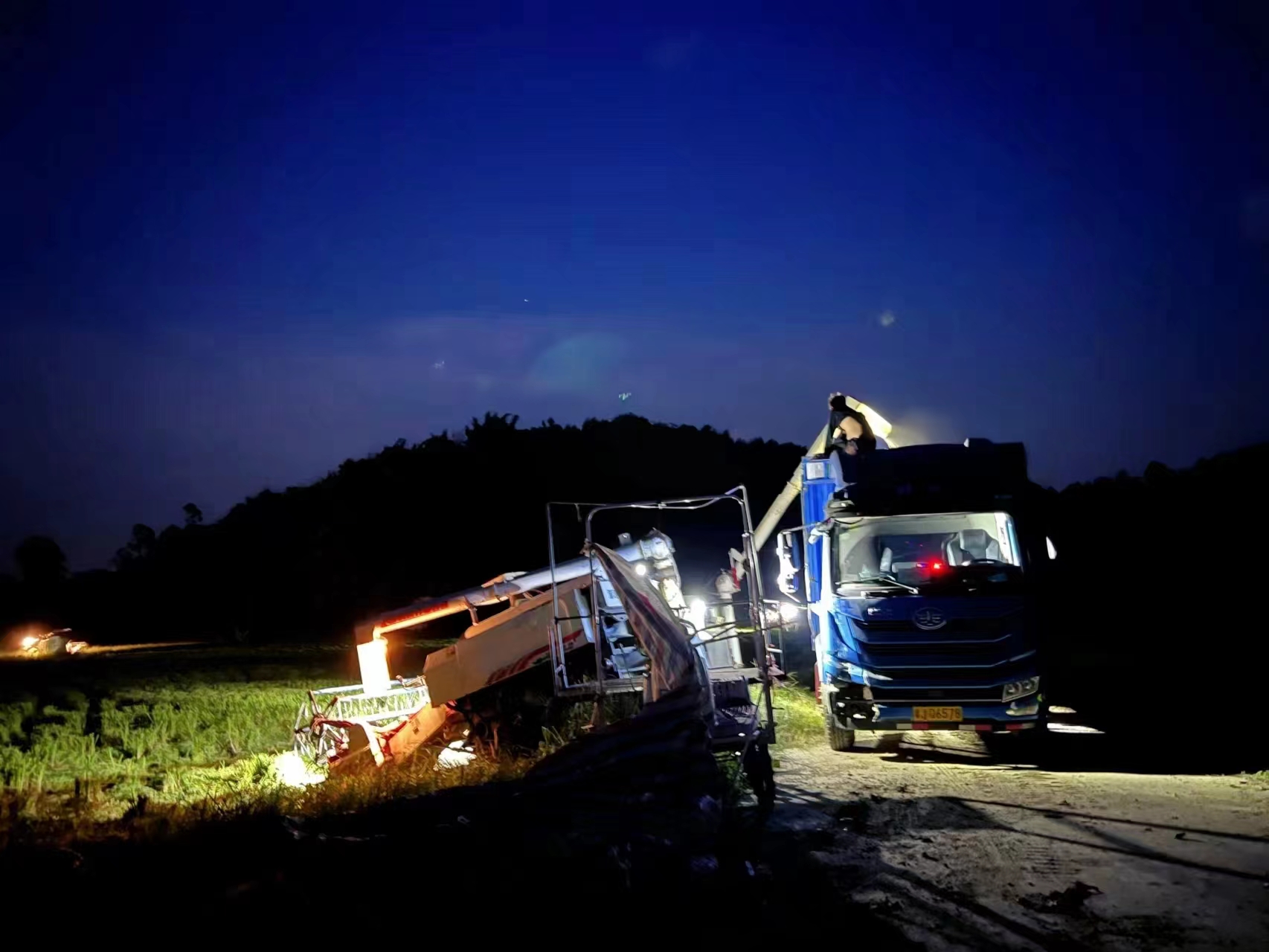 15日深夜，在恩平市牛江镇黄泥坦村田边，村民将刚刚抢收下来的水稻装车送往烘干中心。江门市恩平市委宣传部供图