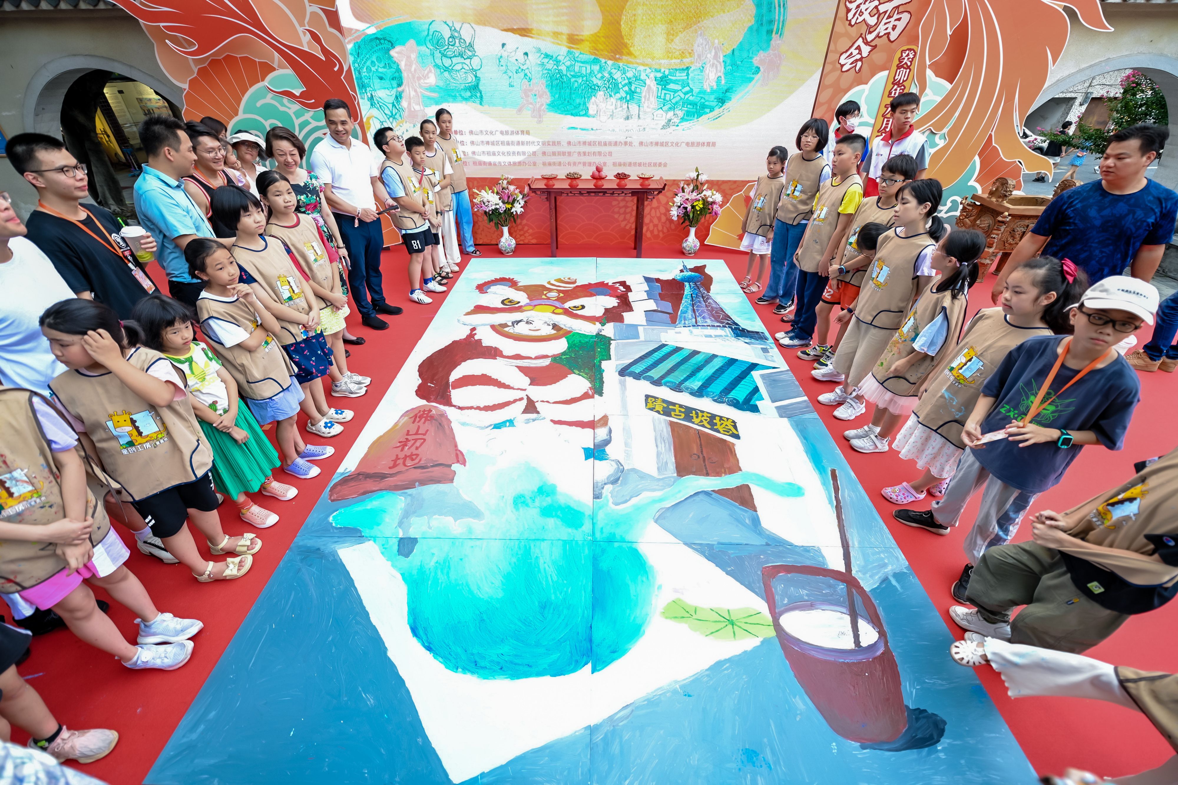 青年藝術家與小朋友共創塔坡廟會主題畫作。祖廟街道宣文辦供圖