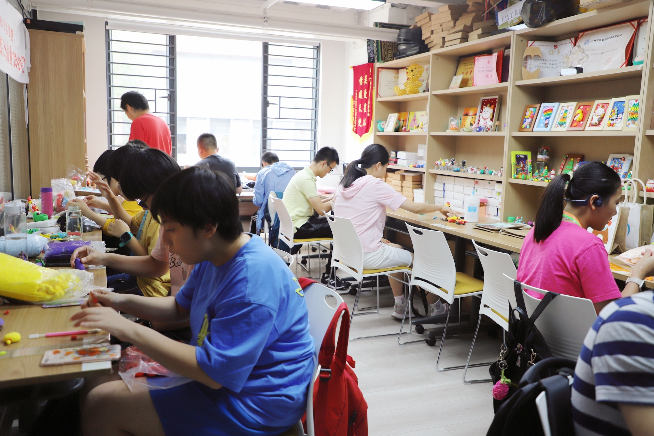 工坊中数十名学员正专注完成自己的作品。刘盈华摄