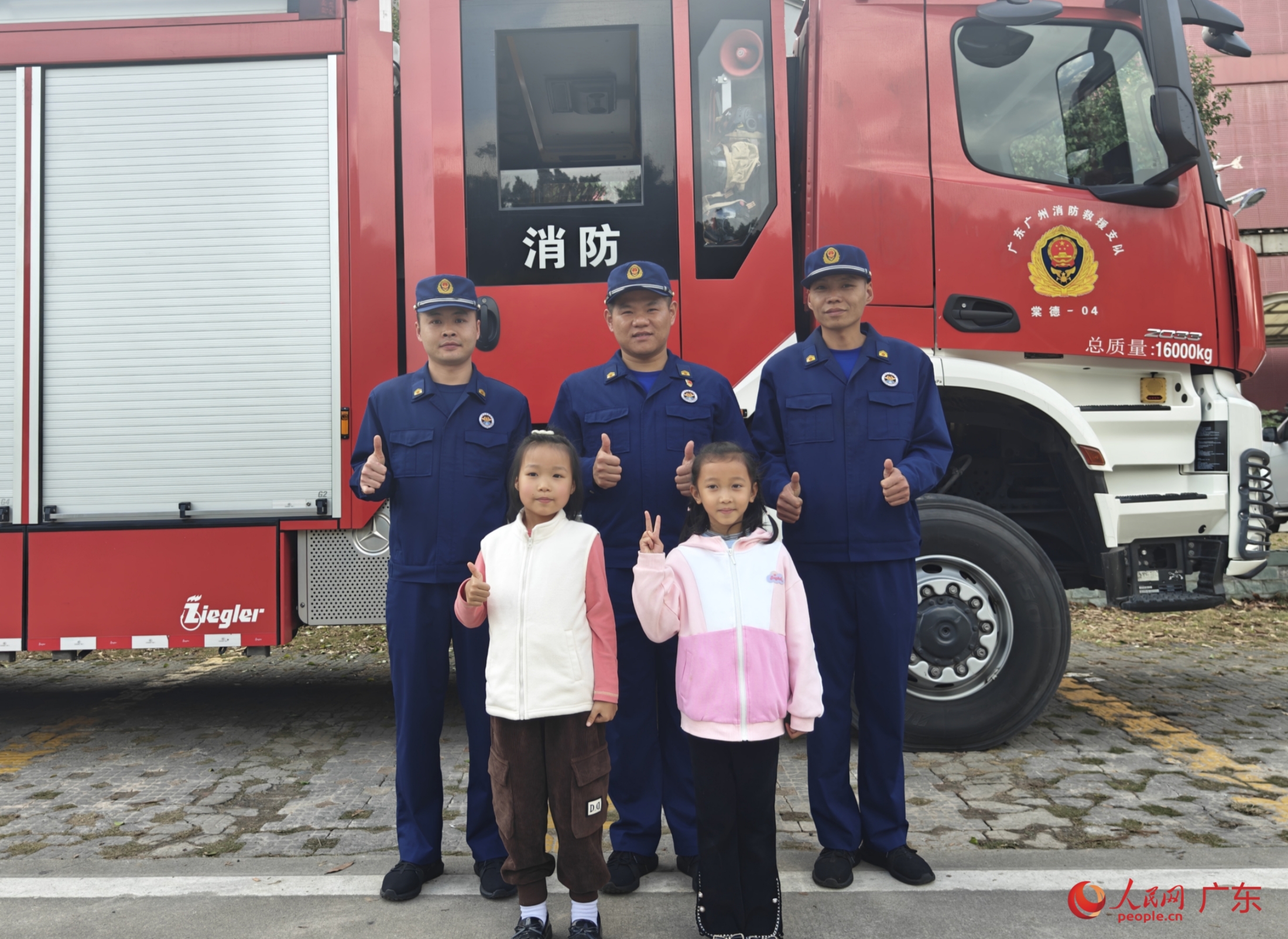 聆听消防安全宣讲后，小朋友与天河区消防救援大队消防员合影留念。人民网 王雅蝶摄