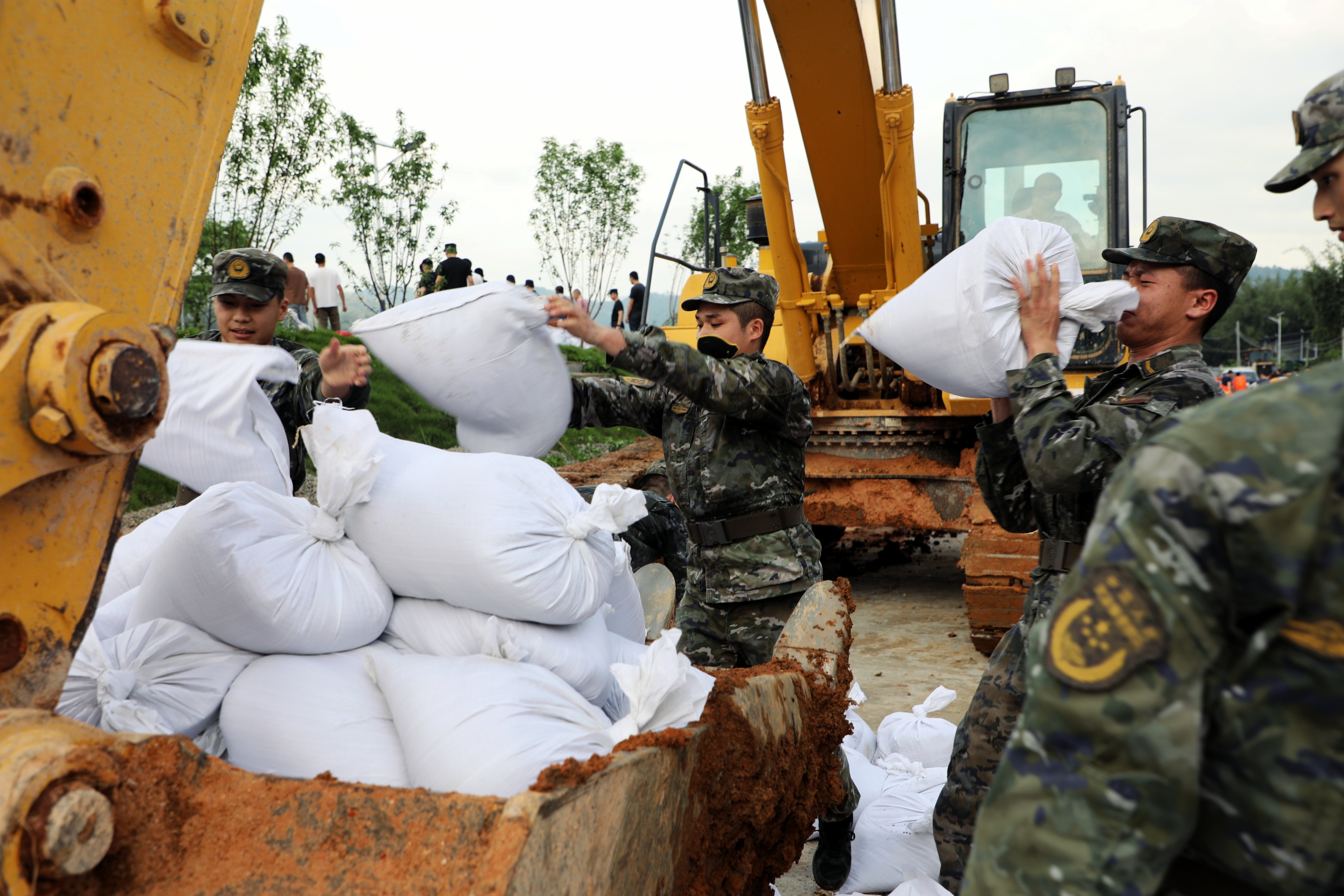 在肇庆，广东武警官兵搬运沙袋，做好加固堤坝工作。武警广东总队供图