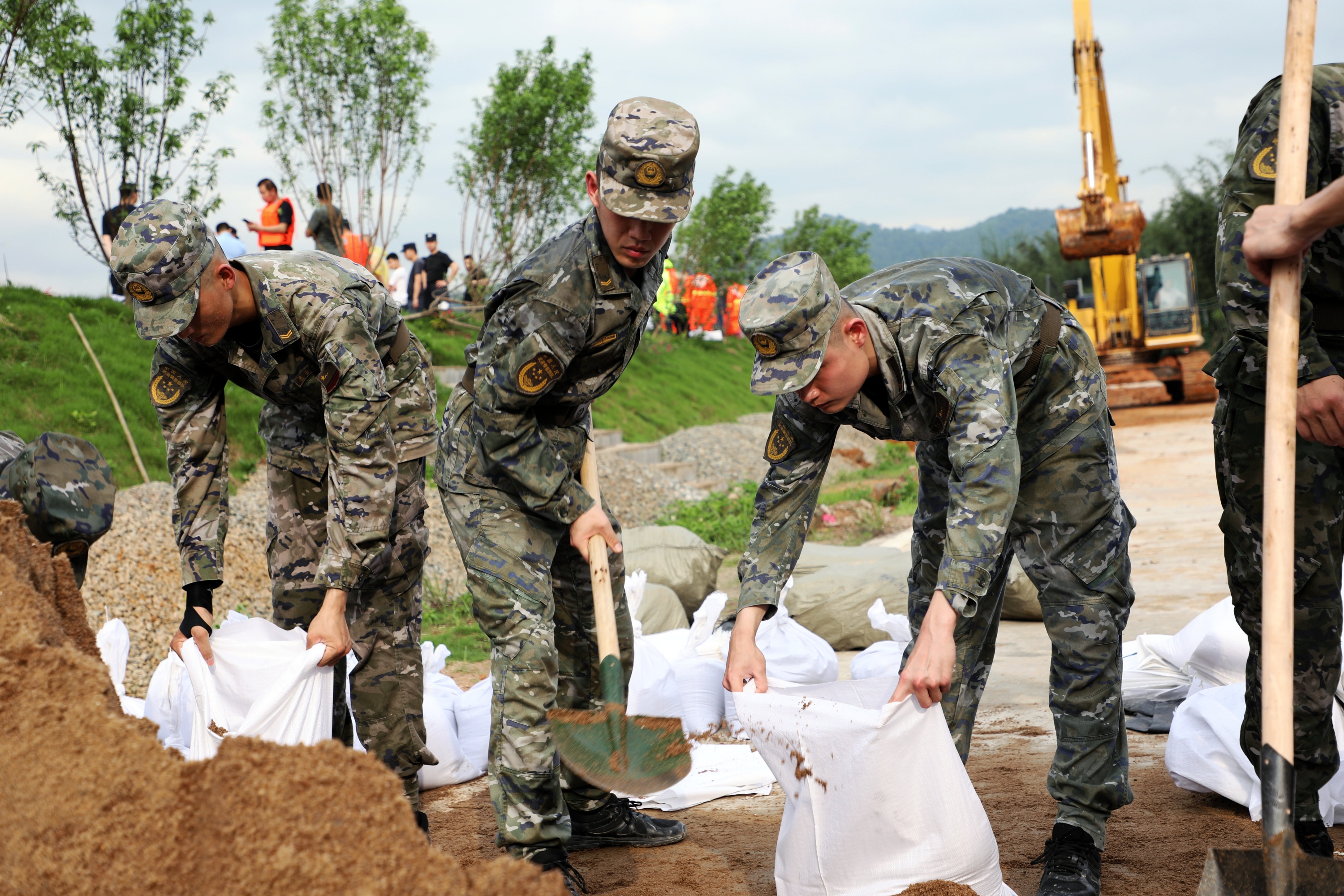 在肇庆,广东武警官兵搬运沙袋,做好加固堤坝工作。武警广东总队供图