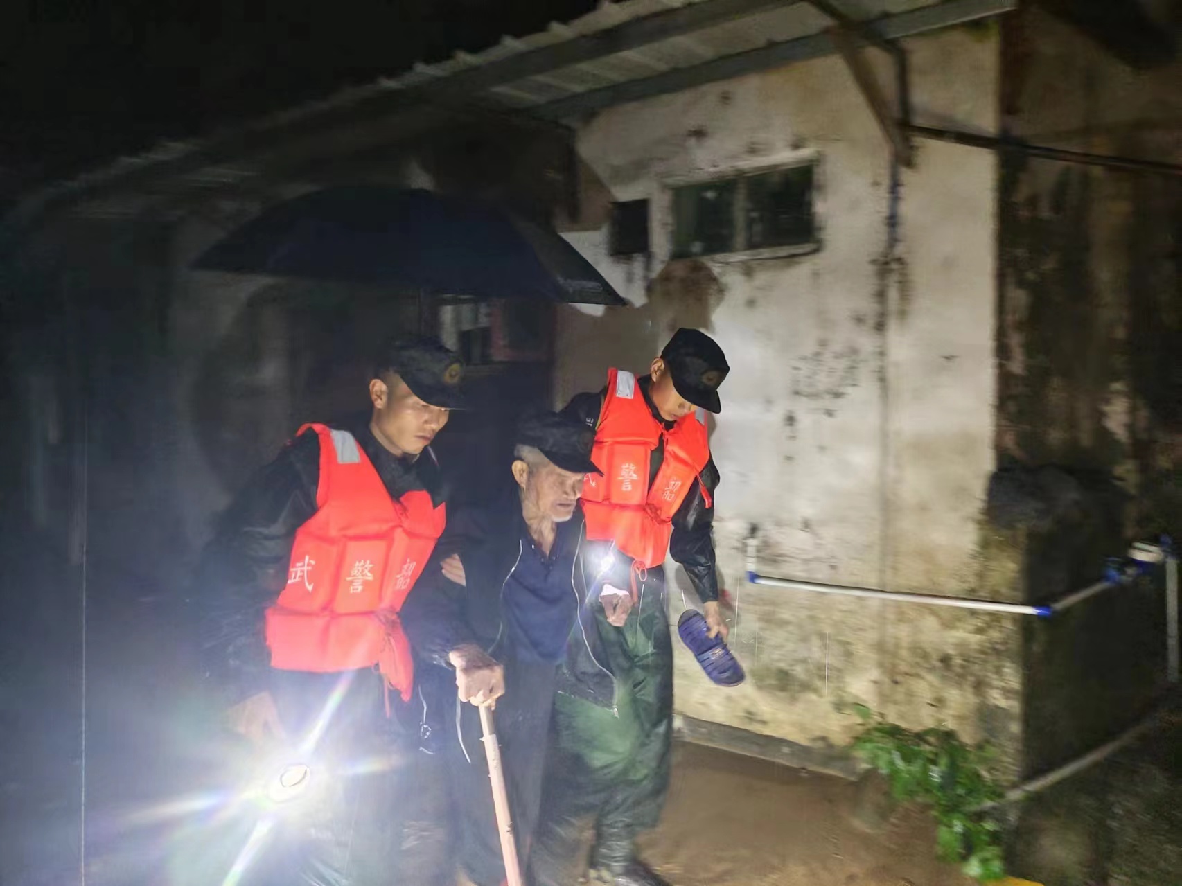 在韶关,广东武警官兵搀扶老人前往安全地带。武警广东总队供图