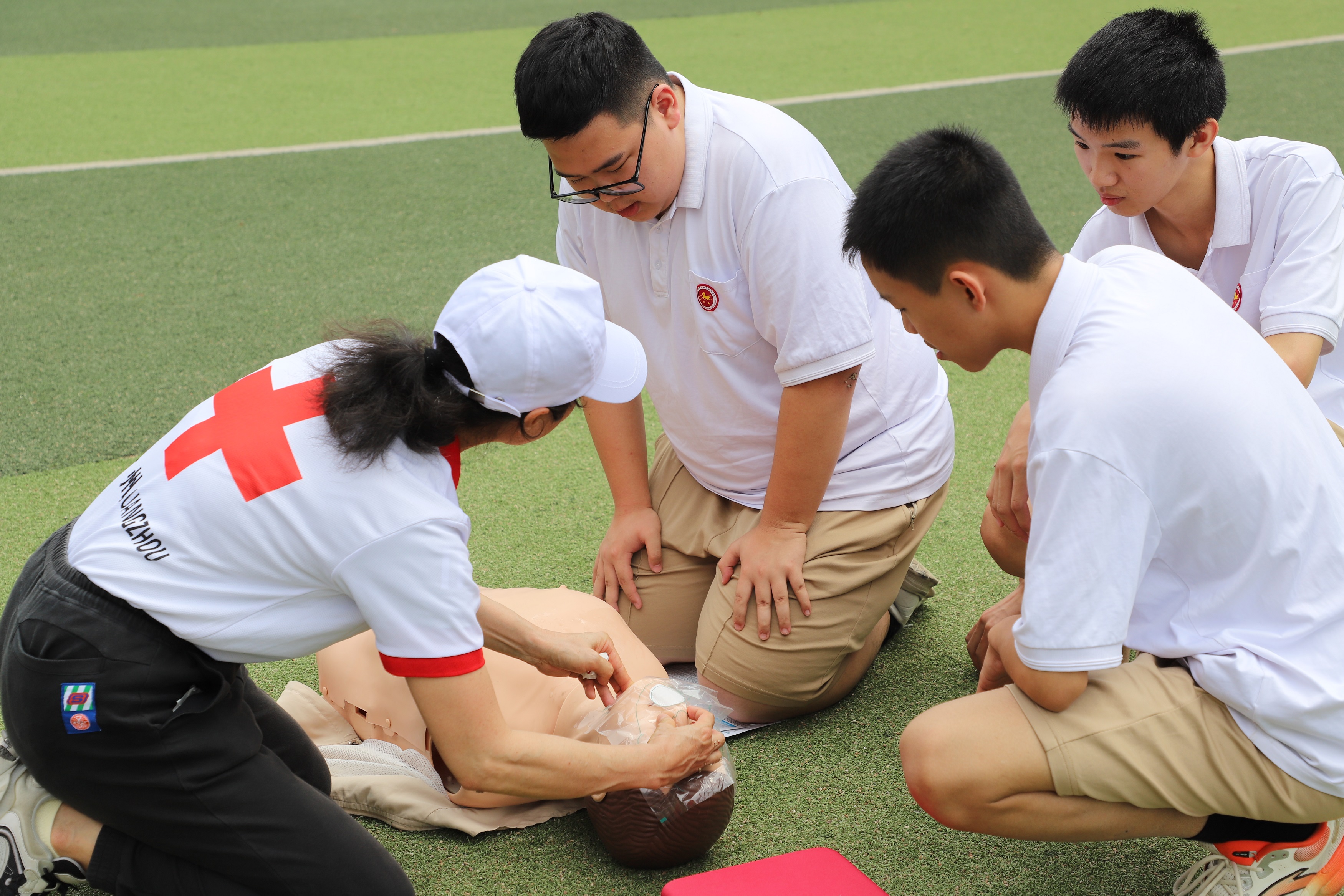 广州市红十字城市救搜队队员向学生们讲解心肺复苏动作要领。人民网 周睿摄