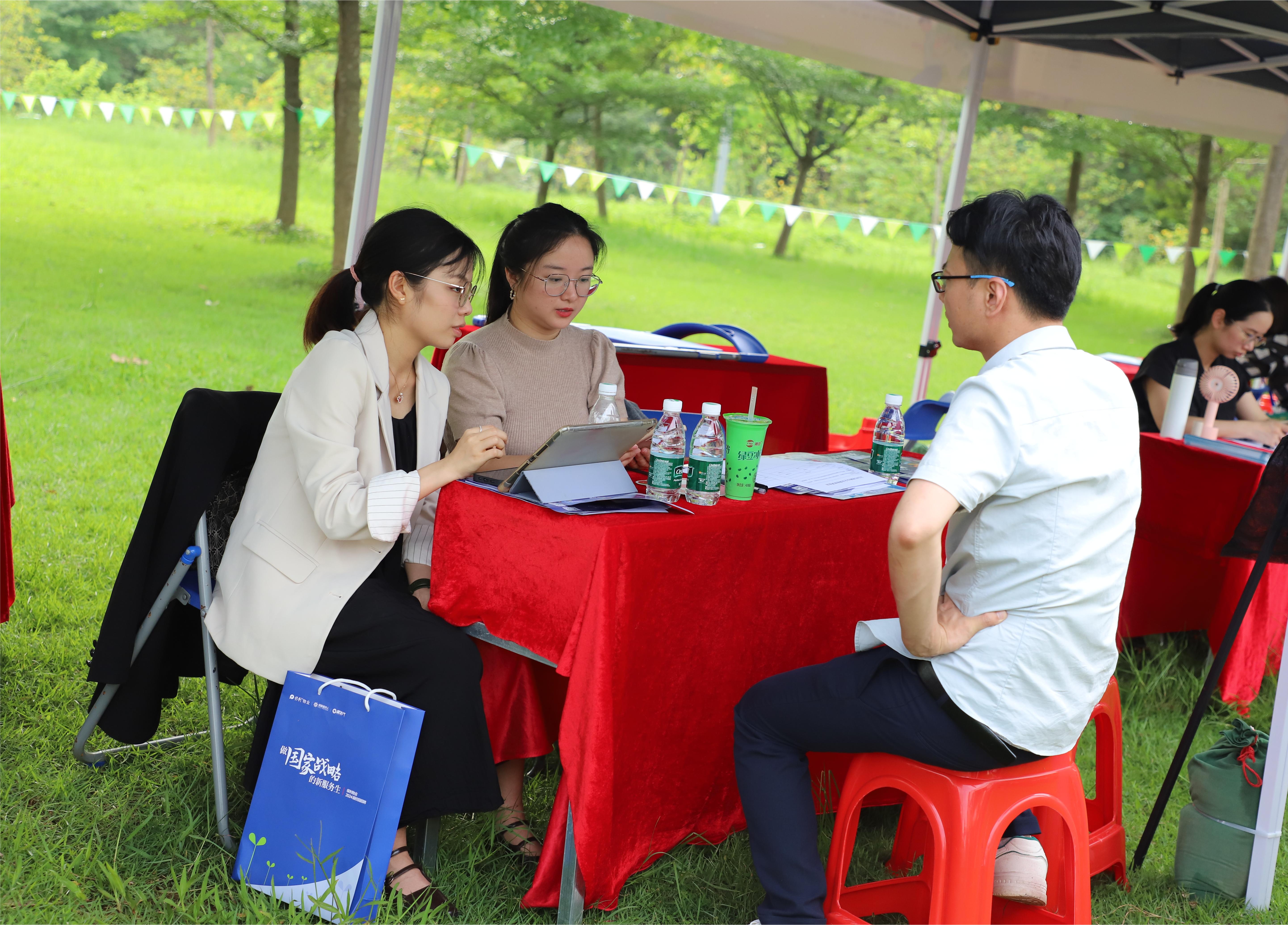 同学们带着简历前来投递，企业代表向同学介绍岗位内容。人民网 宁玉瑛摄
