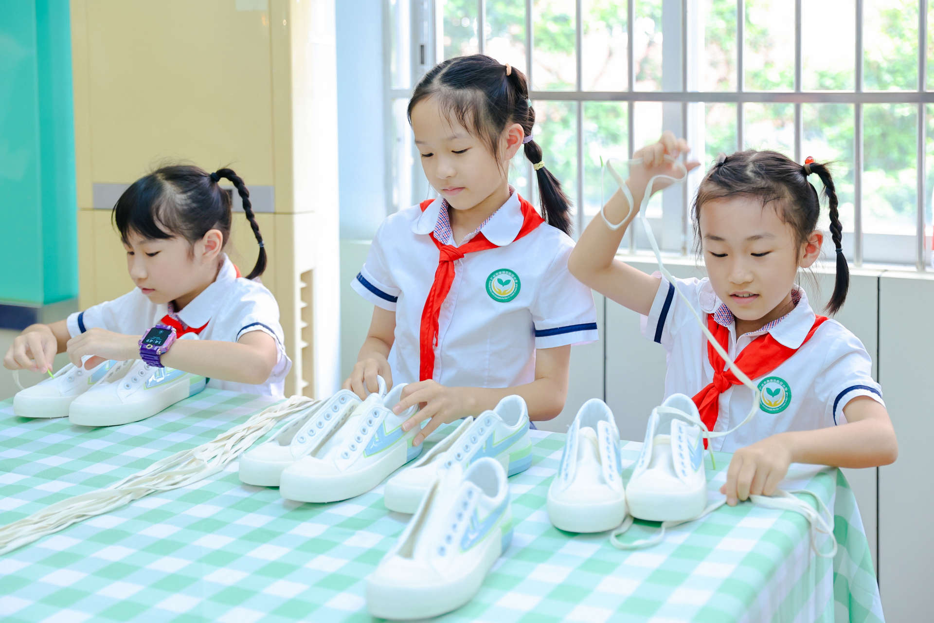 学生们一只只小手牵引着鞋带，在鞋洞里灵巧穿梭。广州市教育局供图