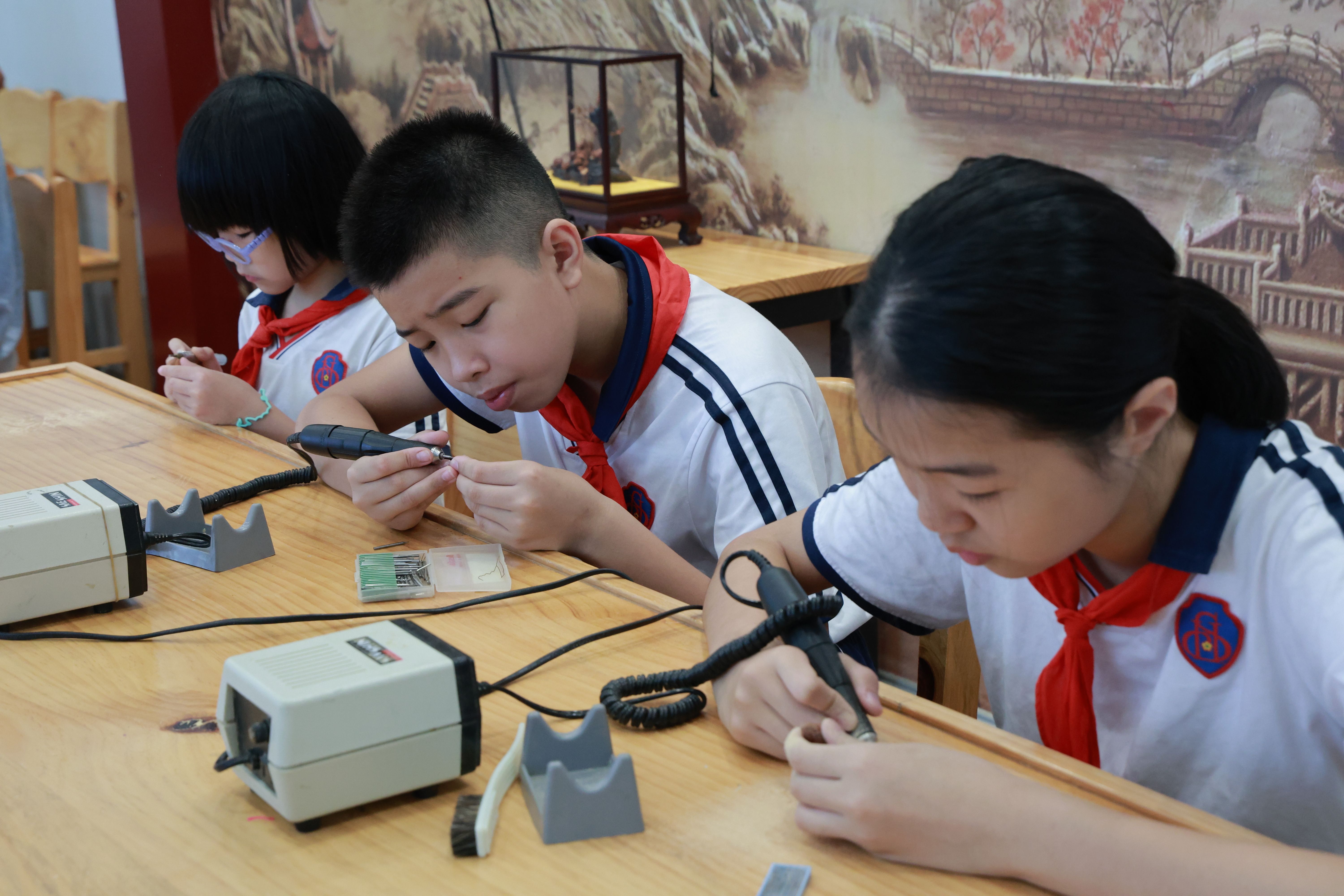 在广州市海珠区实验小学的榄雕课上，同学们正在认真打磨榄壳。广州市海珠区实验小学供图