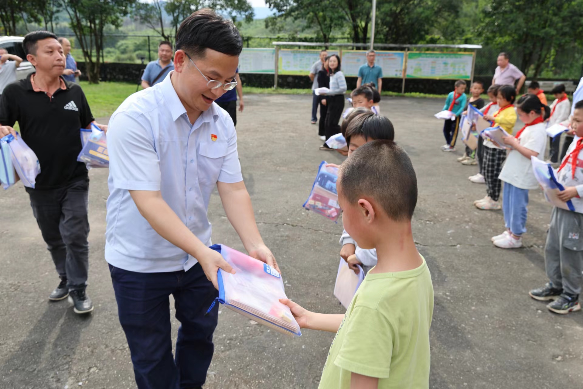 党员志愿者为孩子们送上爱心助学礼包。黄义权摄