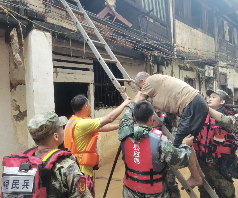 梅州市退役軍人在受災地區轉移受困群眾。廣東省退役軍人事務廳供圖