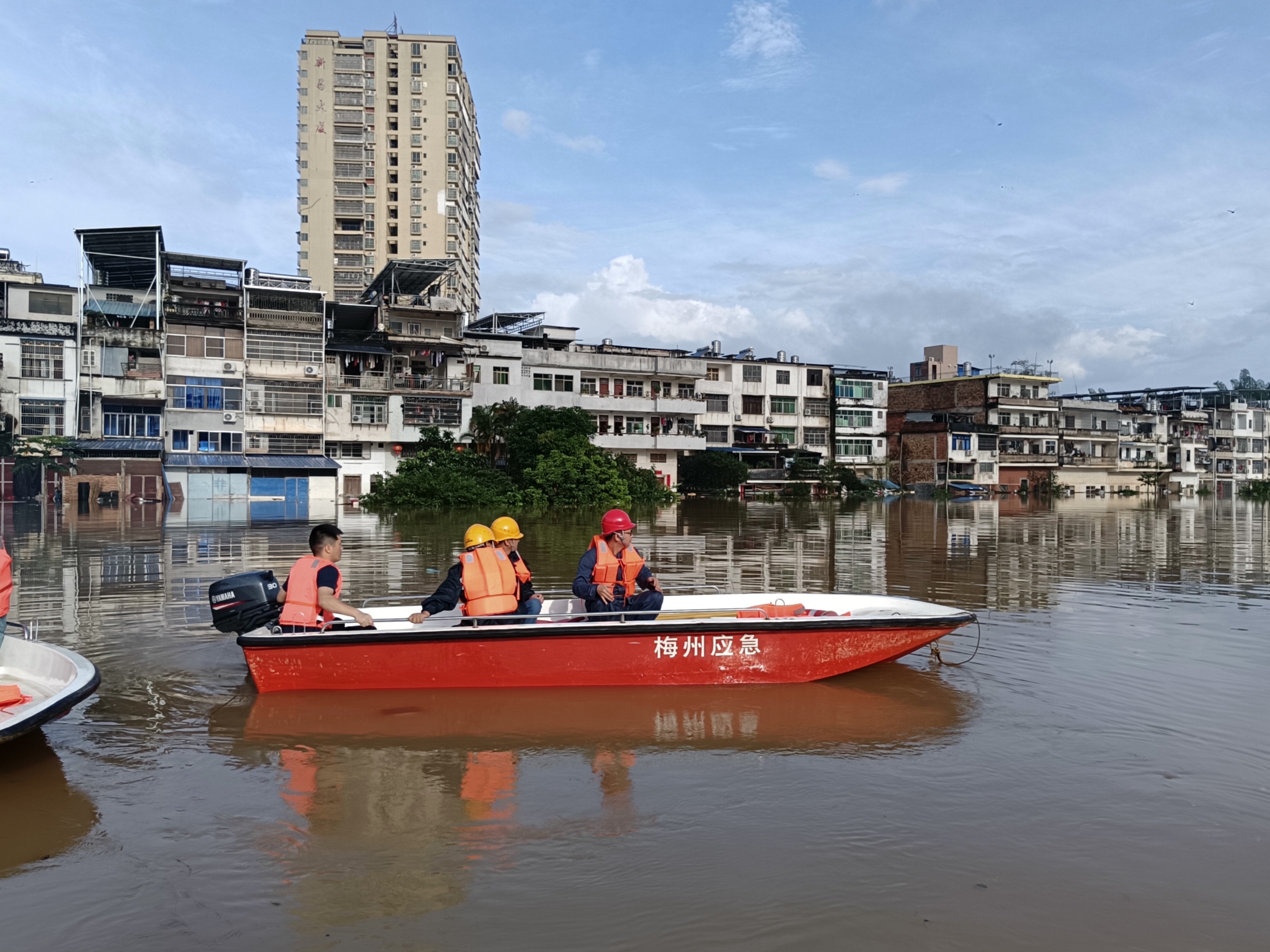 南方电网广东梅州大埔供电局抢修人员乘船前往水浸区域对电力设备进行紧急停运。熊幸摄
