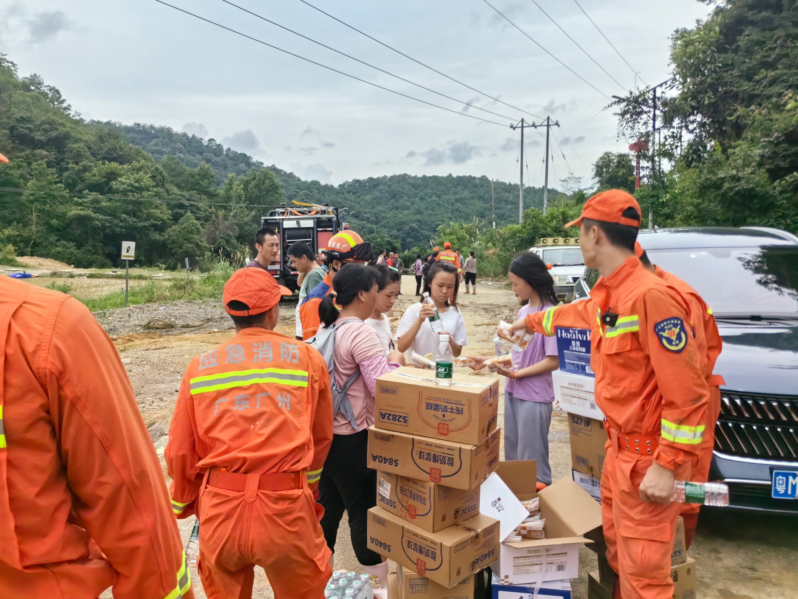 消防救援人员在梅州市受灾地区为群众发放救援物资。广州市消防救援支队供图