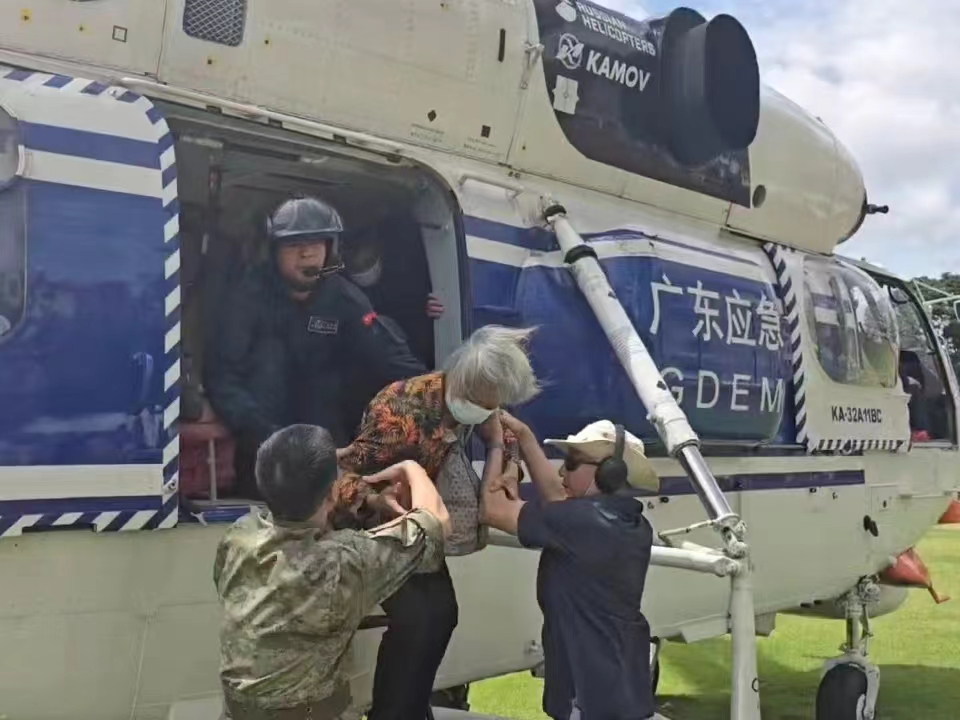 抢险救援人员在梅州市受灾地区合力转移受困群众。广东省应急管理厅供图