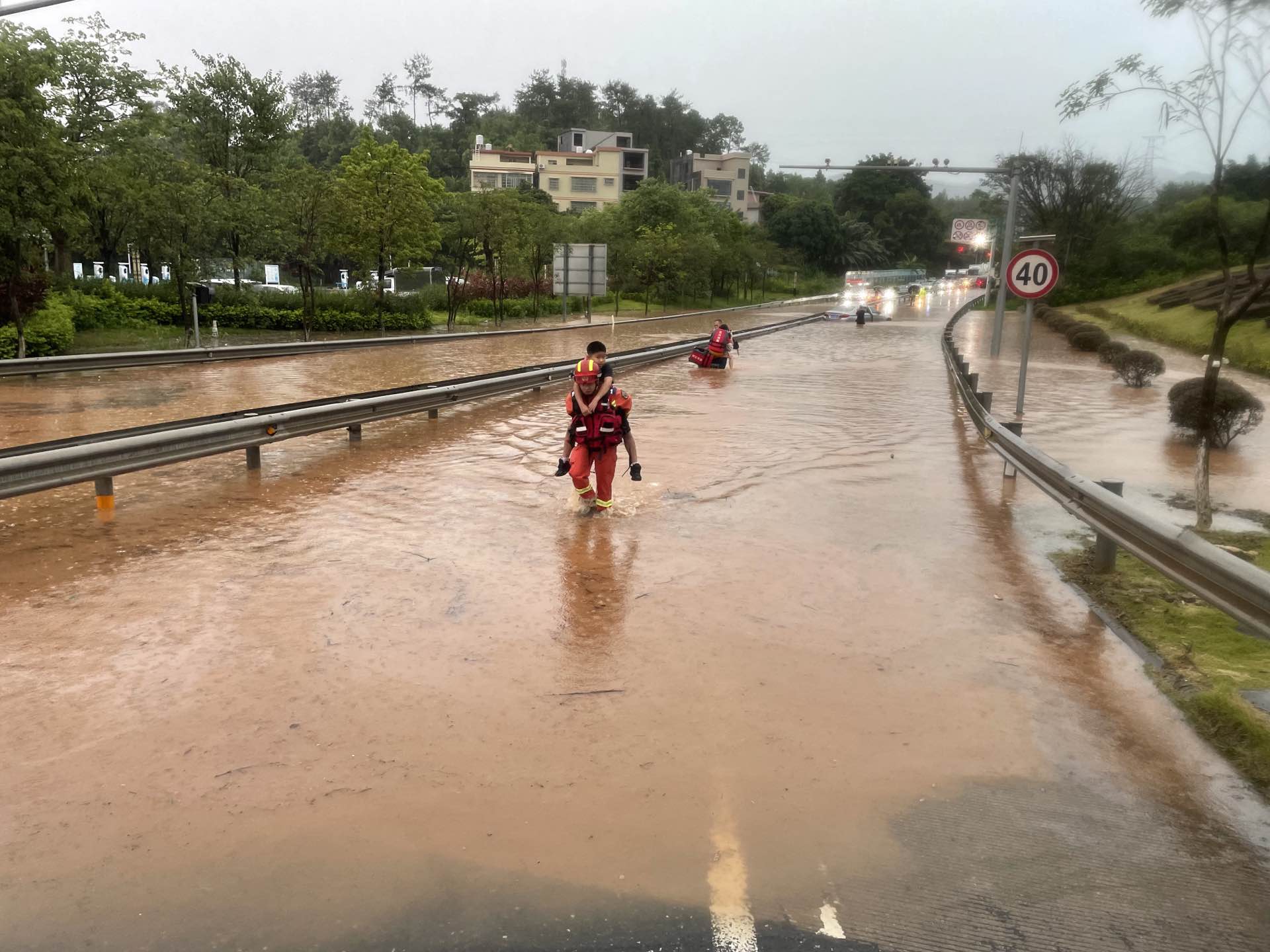 河源市消防救援支队龙川大队消防救援人员转移被困群众。广东省消防救援总队供图