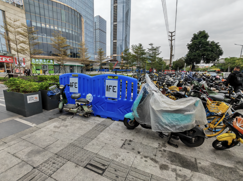 11月19日，广州市天河区科韵路地铁站B出口附近，大量电动自行车、共享单车占用盲道停放，一水马设置在盲道上。人民网 宁玉瑛摄