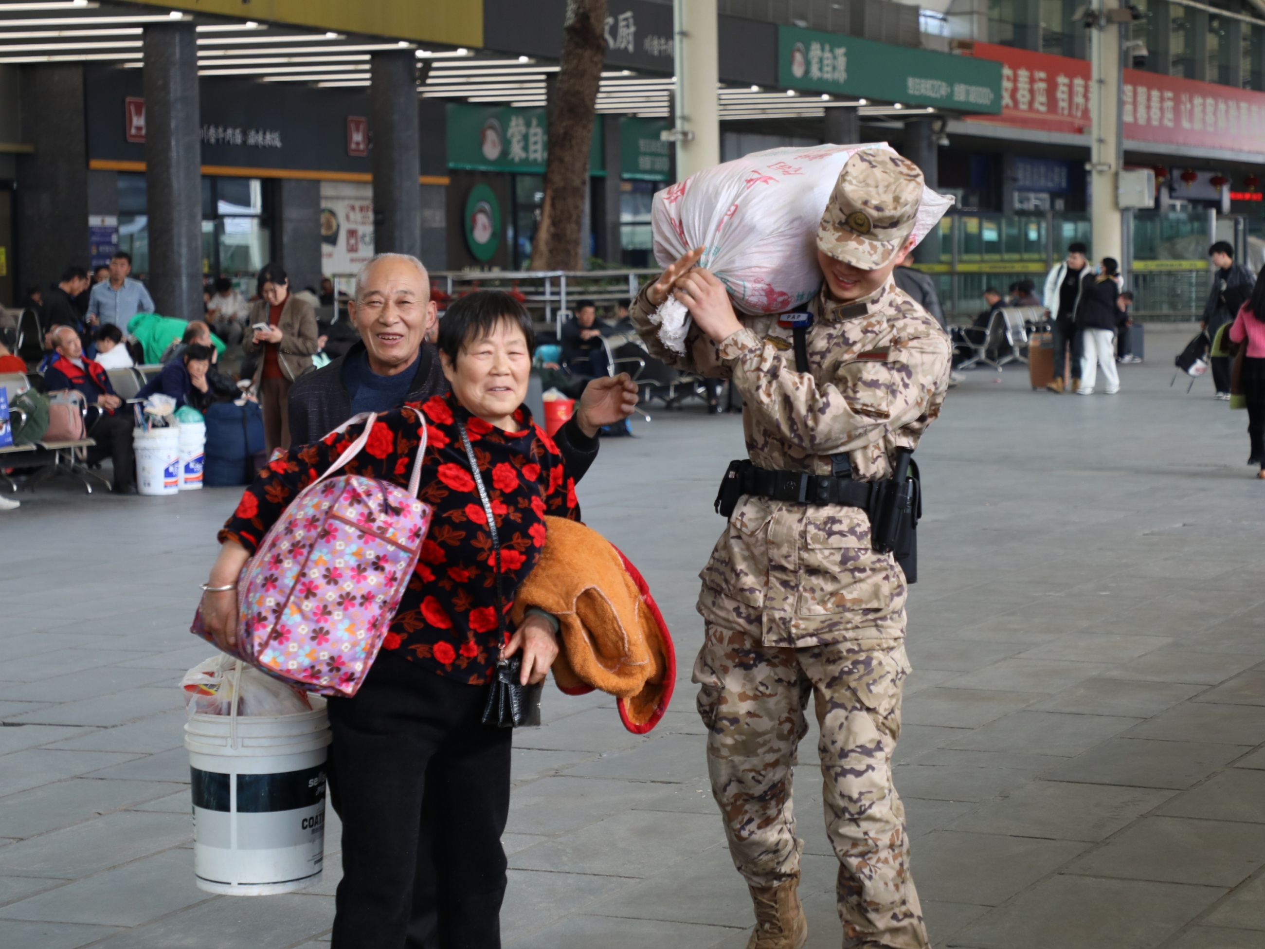 春运首日，在广州火车站执勤的武警广州支队官兵为群众搬运行李。蔡俊龙摄