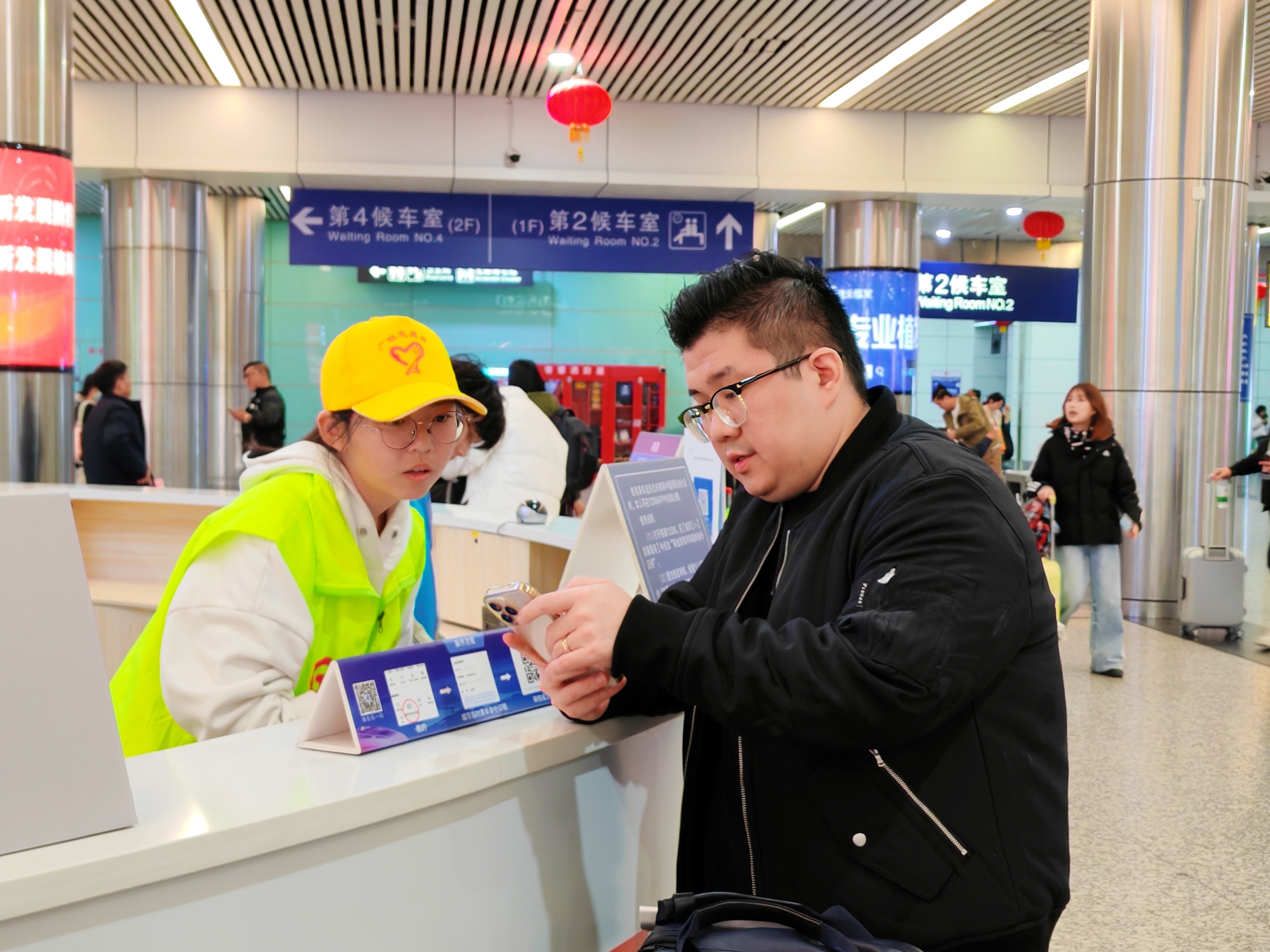 1月14日，广州东站，志愿者解答旅客疑问。人民网 宁玉瑛摄