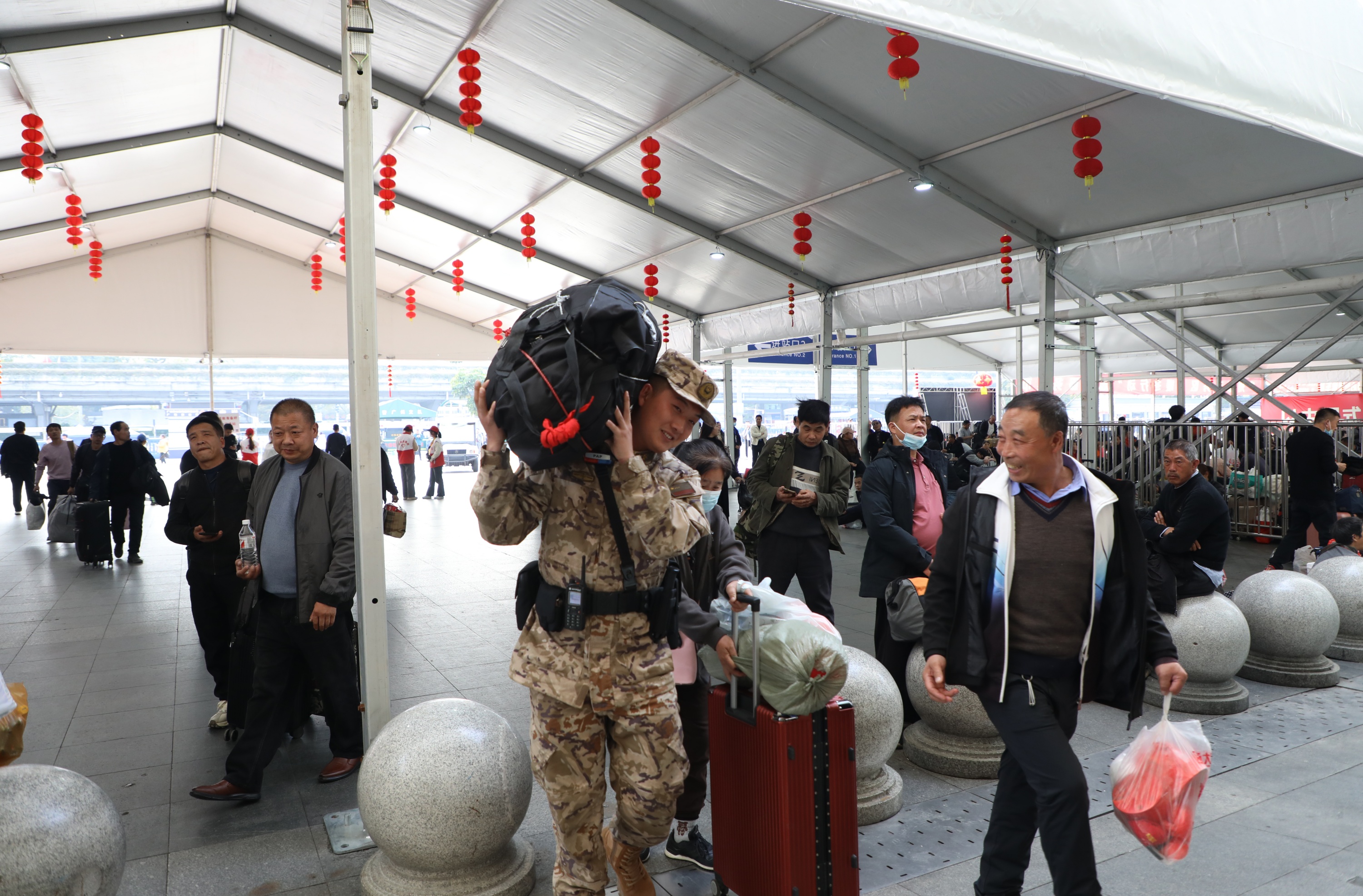 1月14日，在广州火车站执勤的武警广州支队官兵为群众搬运行李。曾阳摄