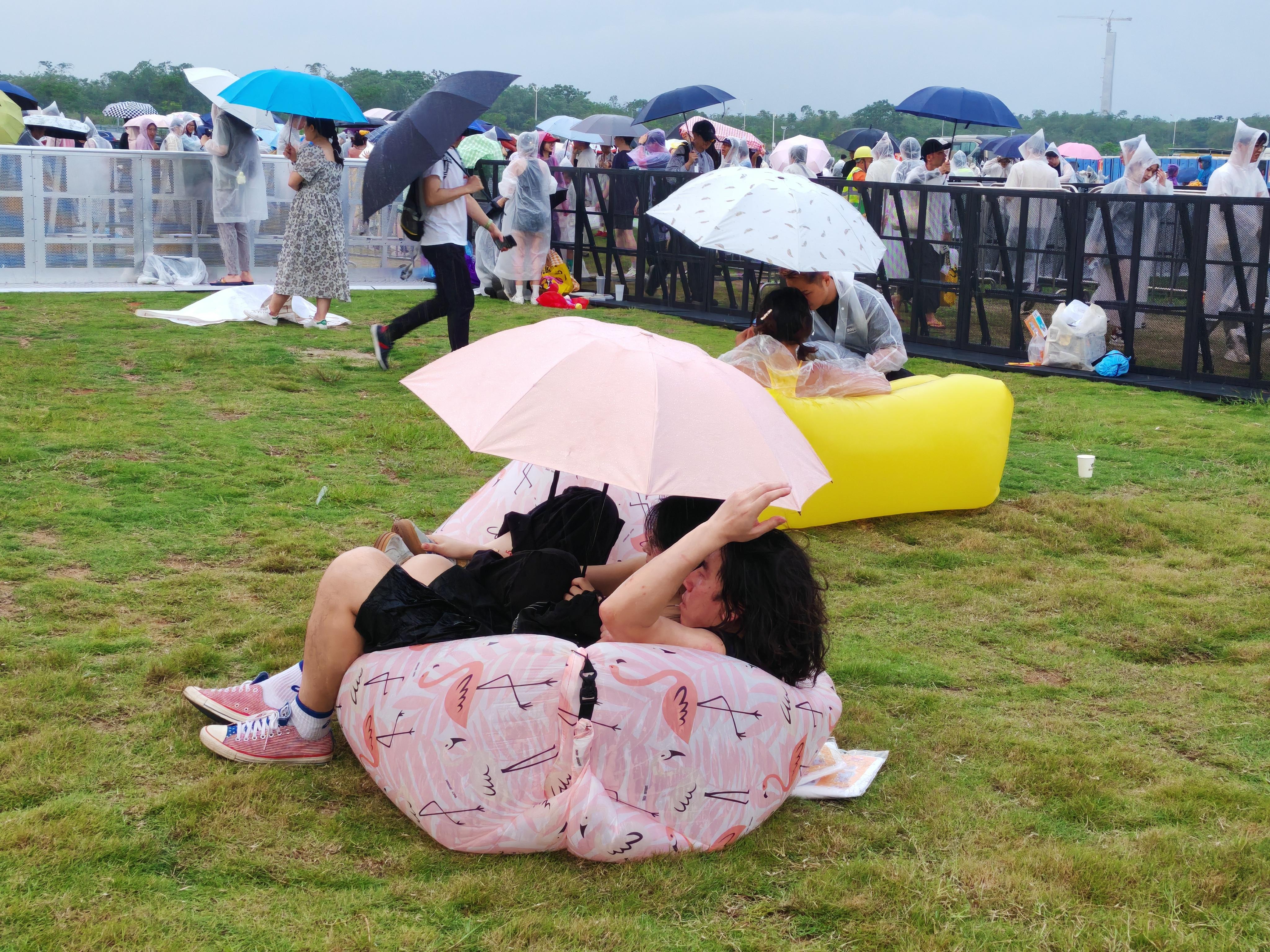 音樂節現場下起雨，觀眾們掏出雨傘，穿上主辦方提供的雨衣。人民網 寧玉瑛攝