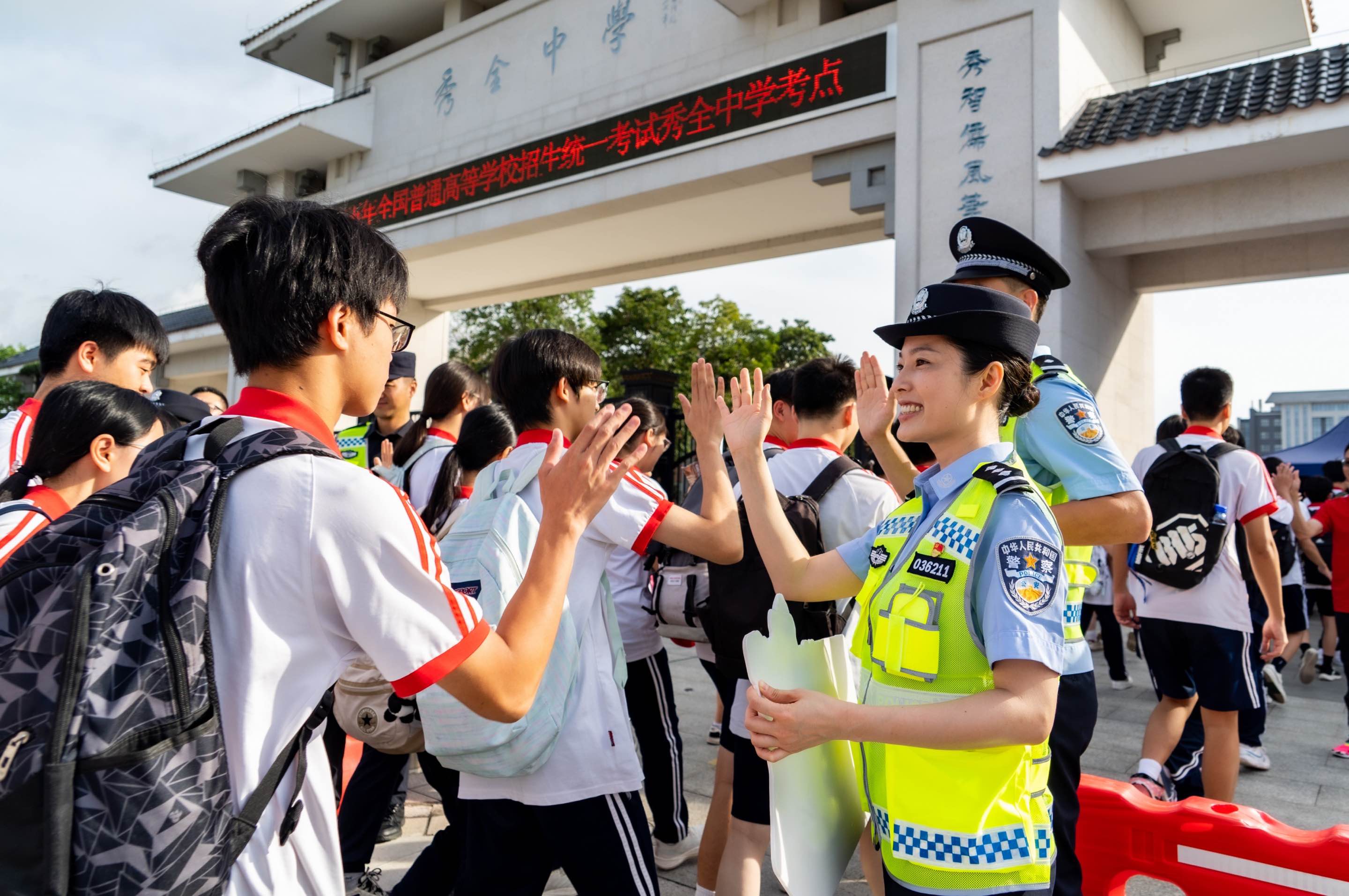 2025年廣東高考期間，廣州花都公安民警在秀全中學與考生擊掌送祝福。廣州市公安局供圖