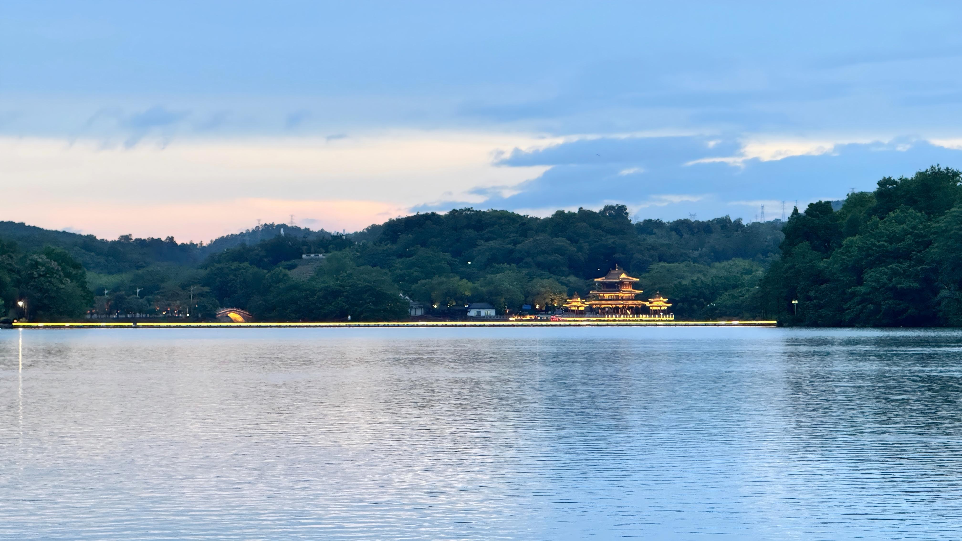 夕陽西下，平靜的湖面泛起金光。陸穎攝