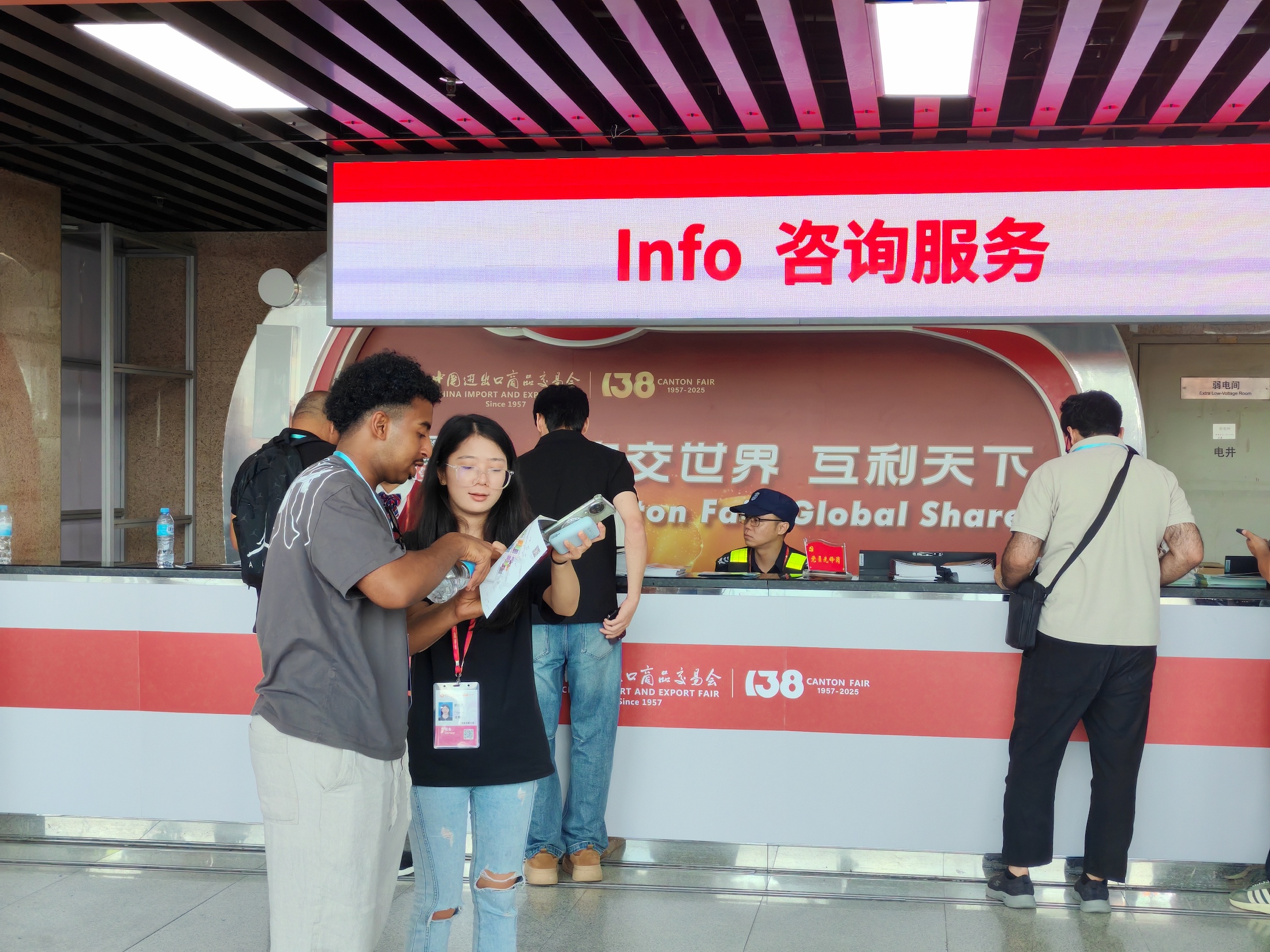 10月15日，广交会现场咨询服务台前，志愿者为海外客商指路。人民网 宁玉瑛摄