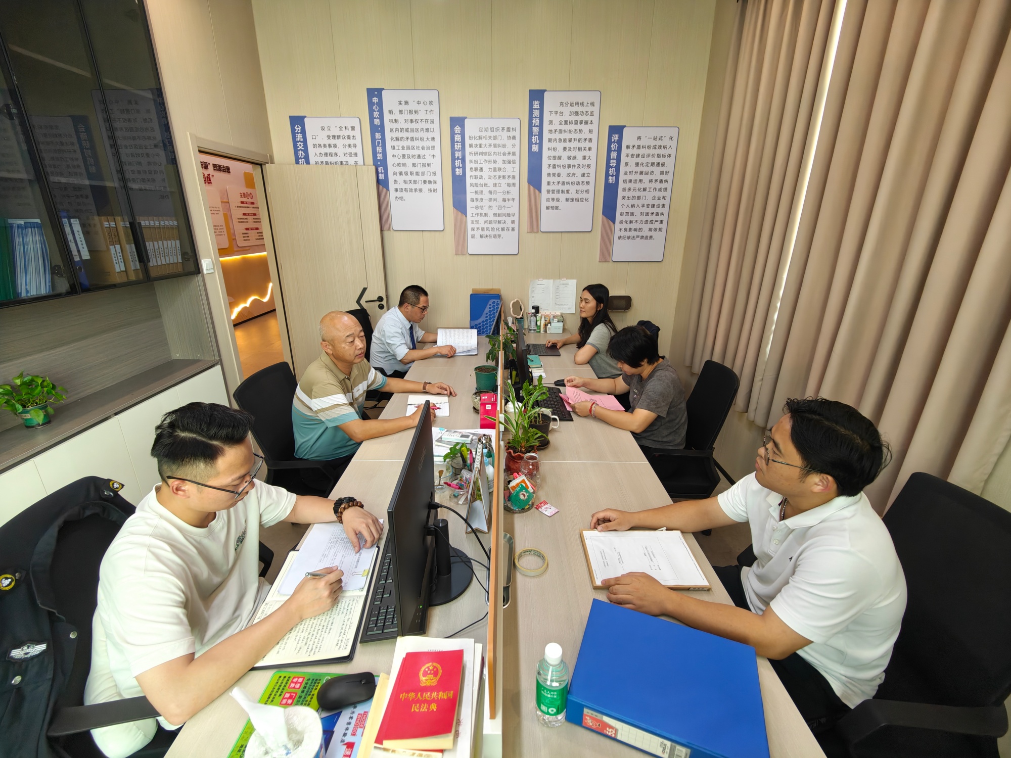 大塘镇工业园区社会治理中心持续推动矛盾纠纷多元化解,图为工作人员开会商讨。人民网记者 王雅蝶摄