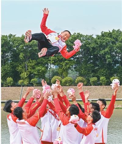 11月11日，在广州举行的第十五届全国运动会赛艇项目男子八人单桨有舵手决赛中，山东队获得冠军，湖北队获得亚军，江苏队获得季军。图为山东队选手将教练员抛向空中庆祝夺冠。新华社记者 肖恩楠摄