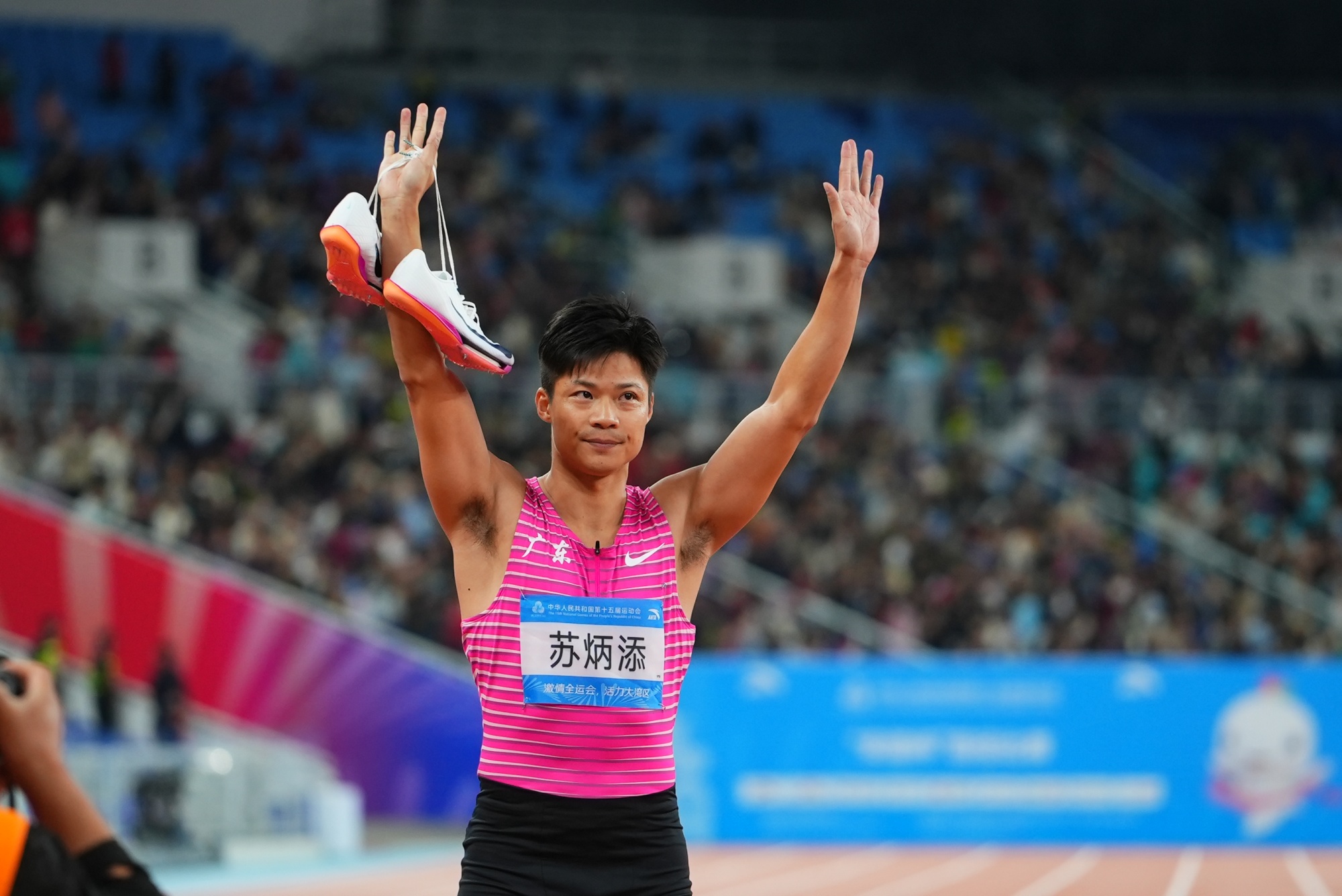 赛后，苏炳添举起跑鞋，寓意“完成职业生涯最后一场比赛”。曾俊荣摄