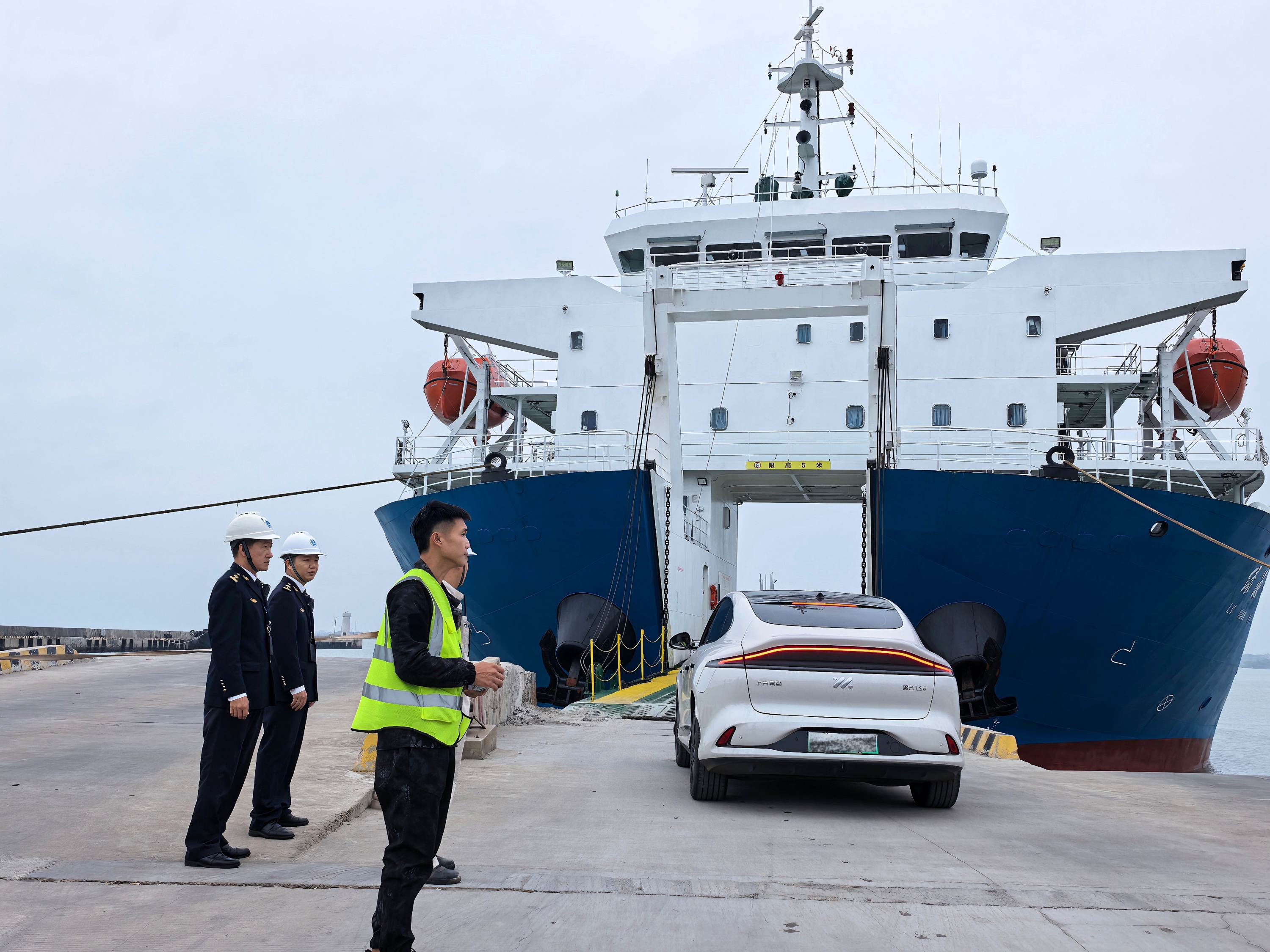 在广东省湛江市海安新港，湛江海事局执法人员与工作人员维护车辆登轮秩序。曾旭豪摄