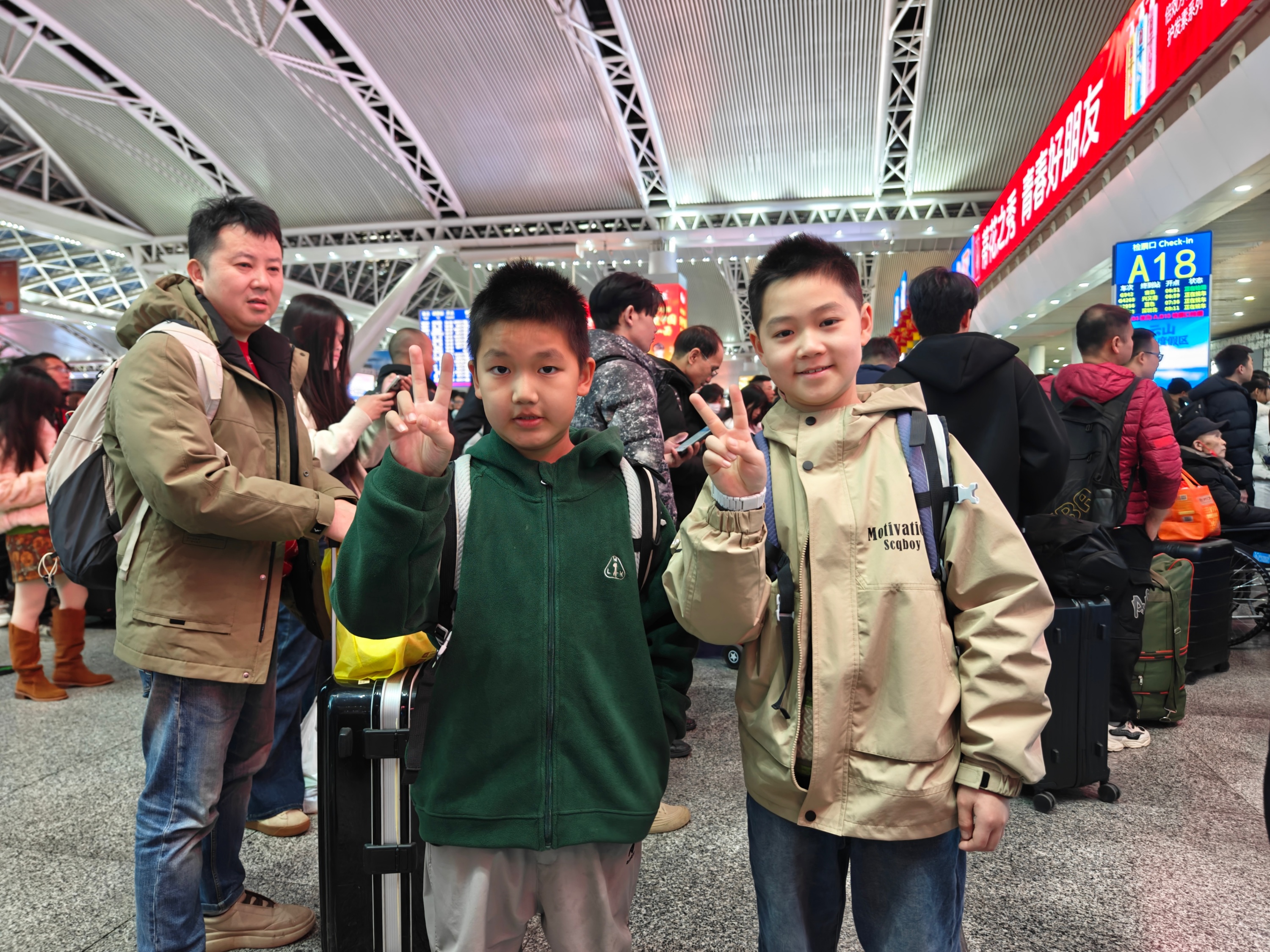 2月2日，广州南站，两位小朋友在家长的带领下，准备回老家贵州过年。人民网记者 王雅蝶摄