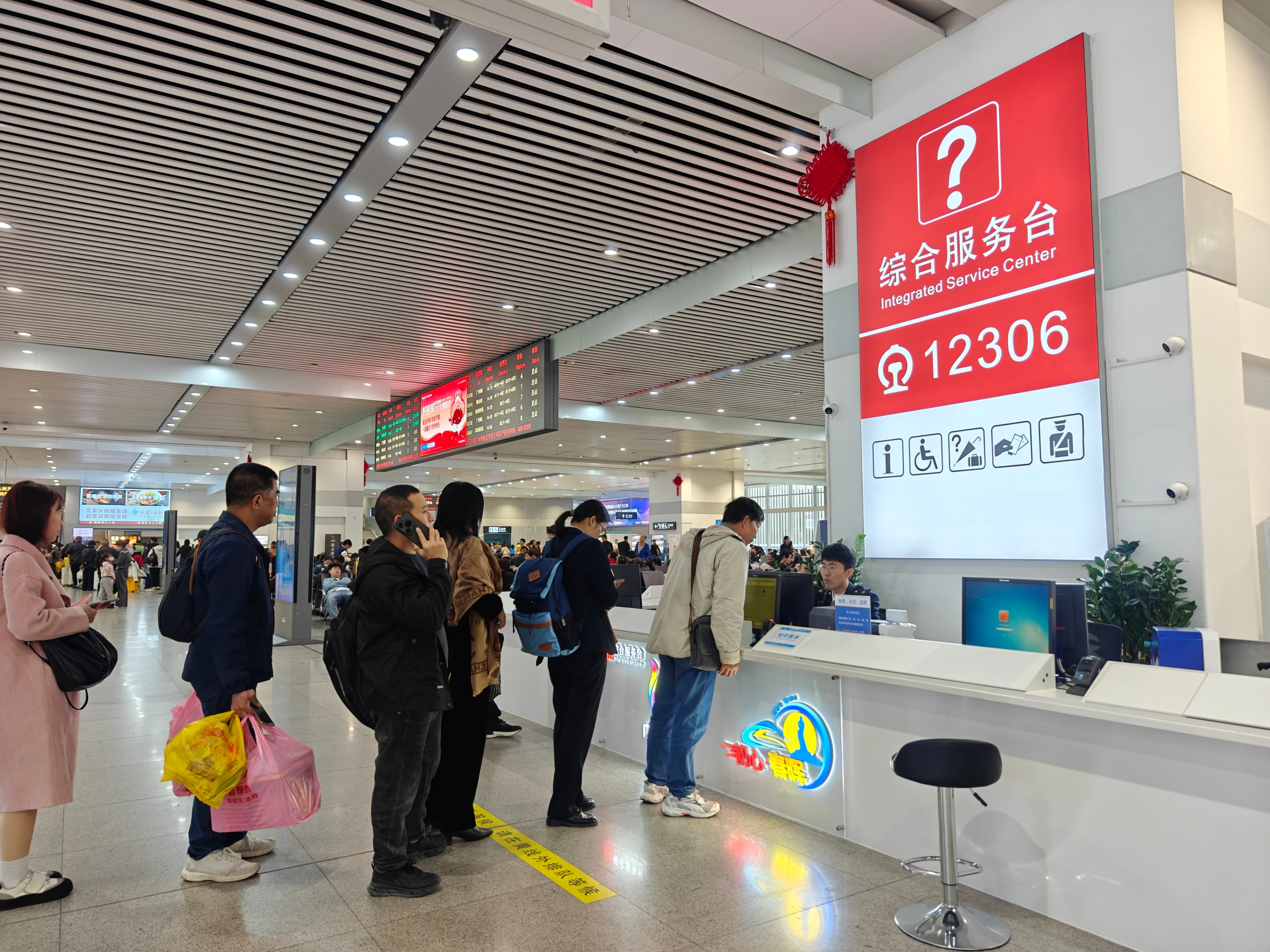 2月3日,珠海站,工作人員在綜合服務台為旅客答疑解惑。人民網記者 王雅蝶攝