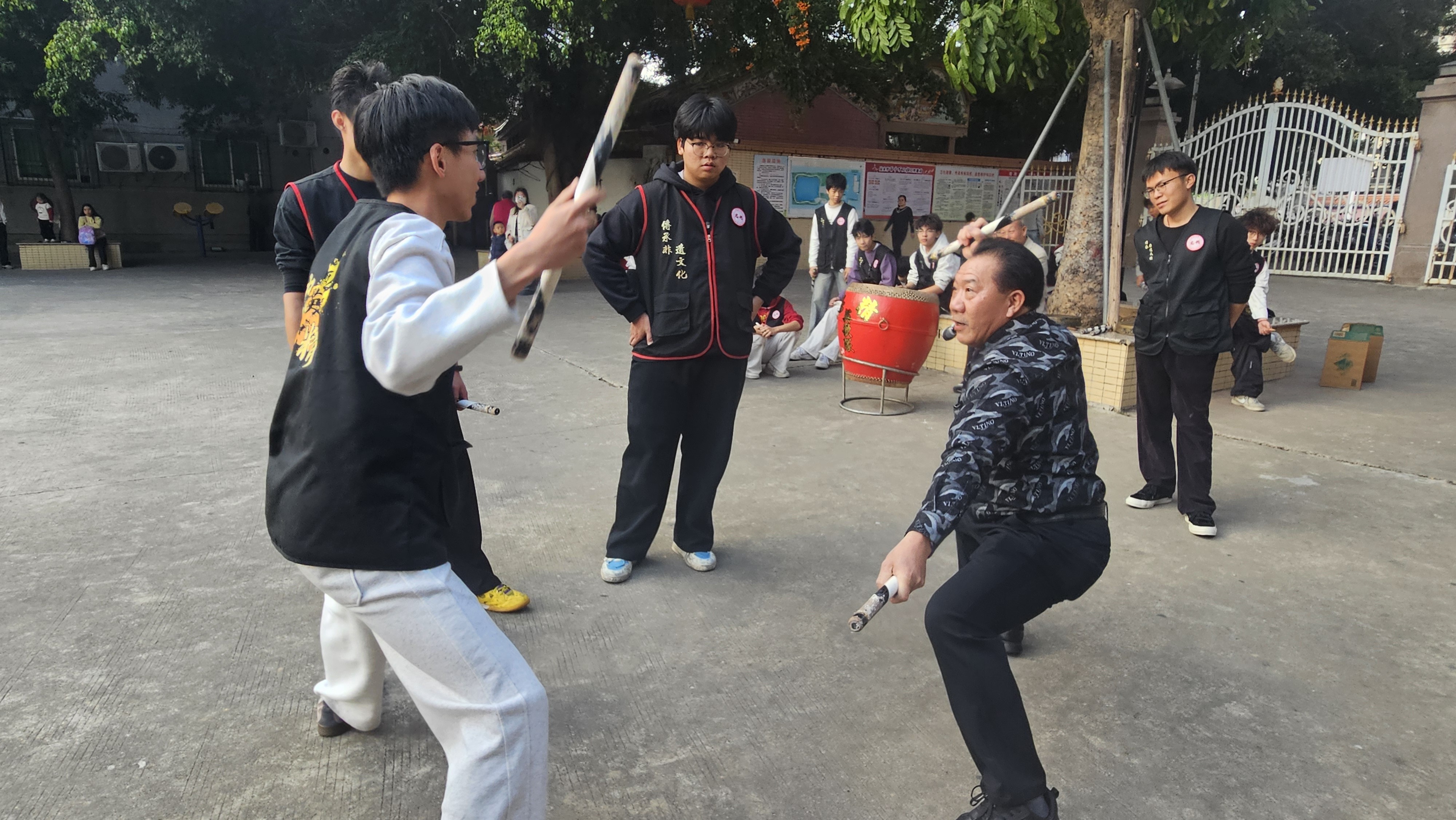 翁丁侠（右二）向寒假返乡大学生传授动作要领。人民网 张永生摄