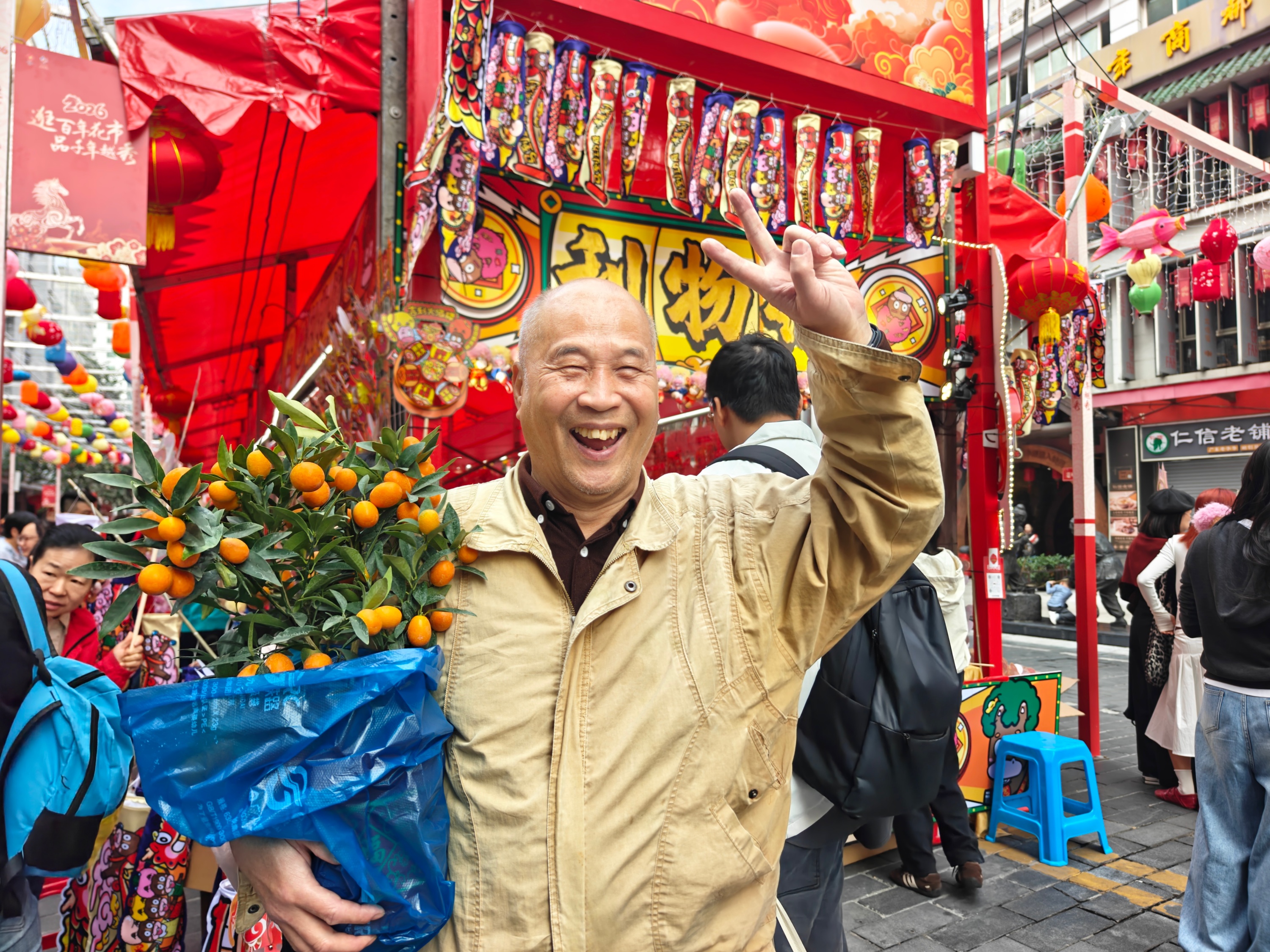 2026年越秀西湖花市，市民李先生买到了心仪的金桔，笑容灿烂。人民网记者 王雅蝶摄