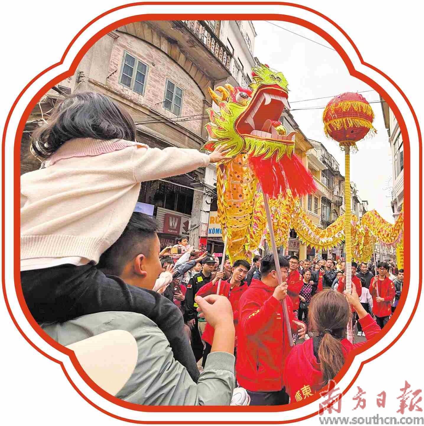 在江门蓬江长堤历史文化街区,舞龙表演吸引游客围观。叶芷晴摄