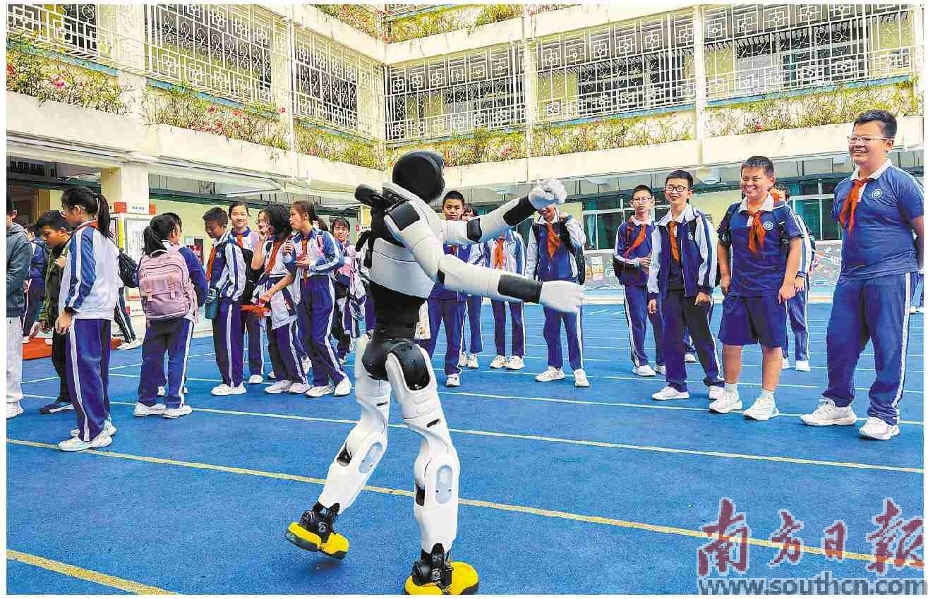  广东大中小学的“开学第一课”正将科技深度融入思政教育当中。图为在深圳怡翠实验学校，人形机器人与学生进行互动。南方日报记者 朱洪波 通讯员 苏仪摄