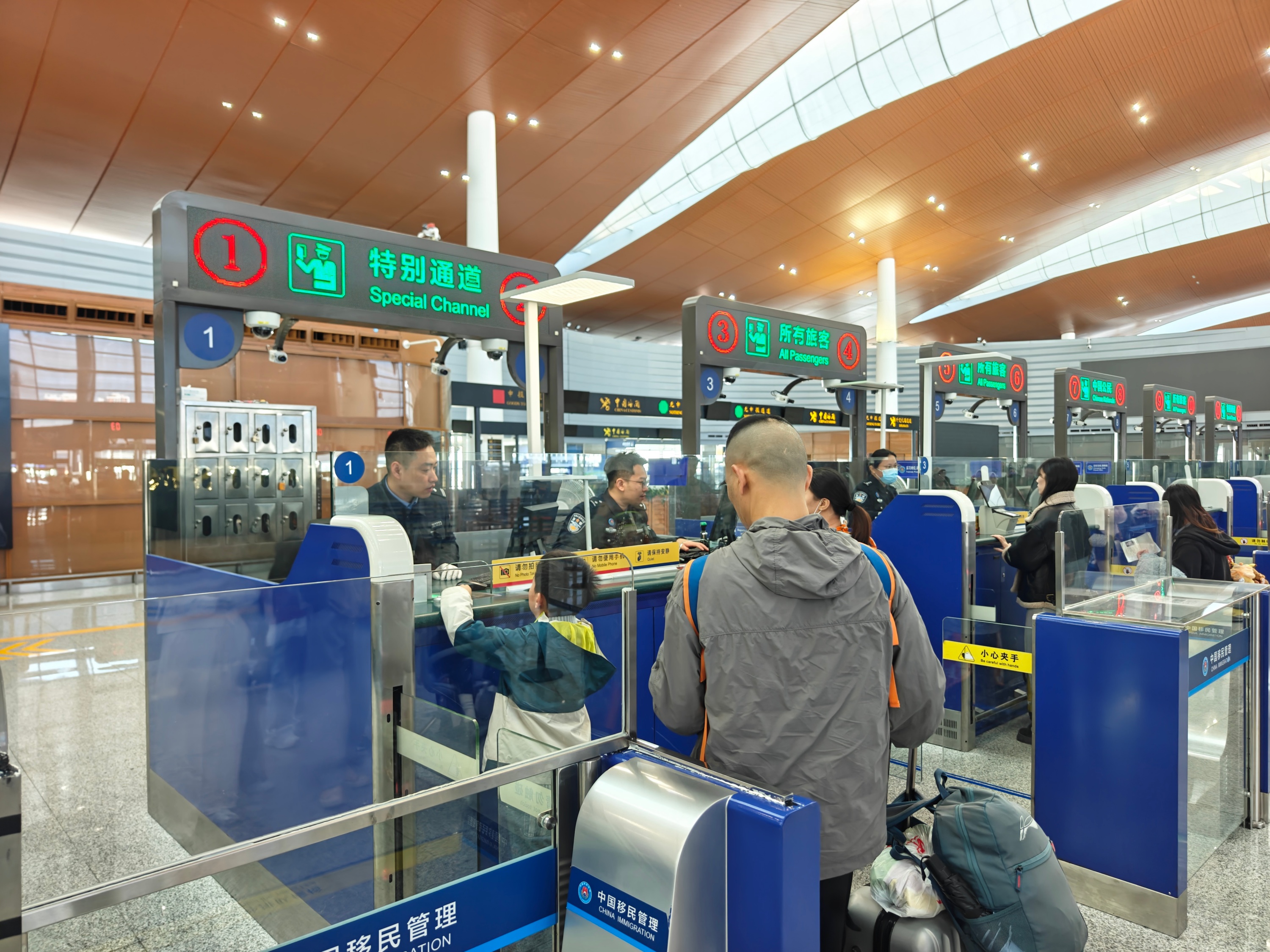 今年春运期间，港珠澳大桥珠海公路口岸，边检民警查验出境香港的旅客证件。人民网记者 王雅蝶摄