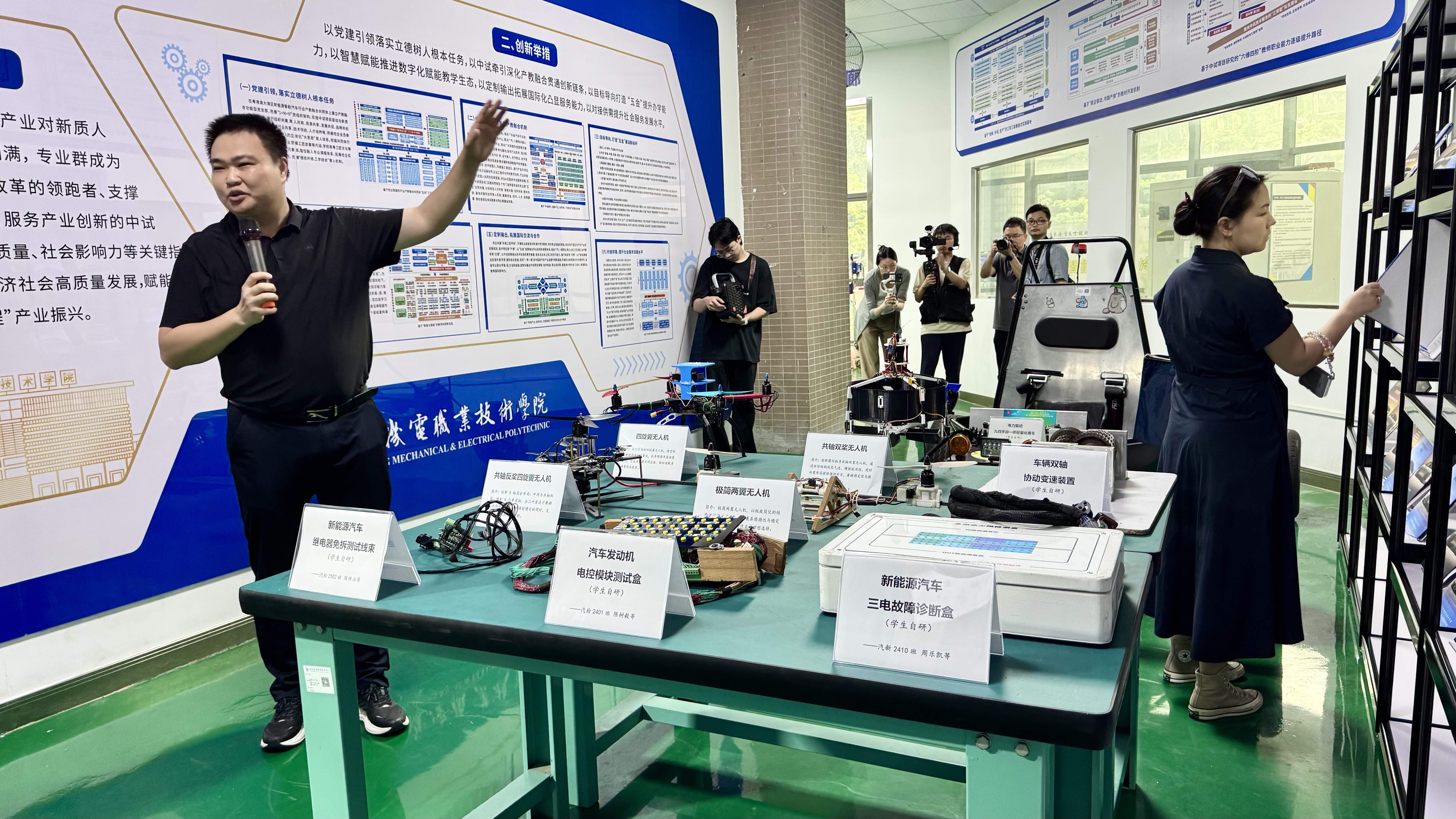 广东机电职业技术学院汽车学院相关负责人正向记者介绍汽车实训设备等创新成果。人民网记者 李昊洋摄