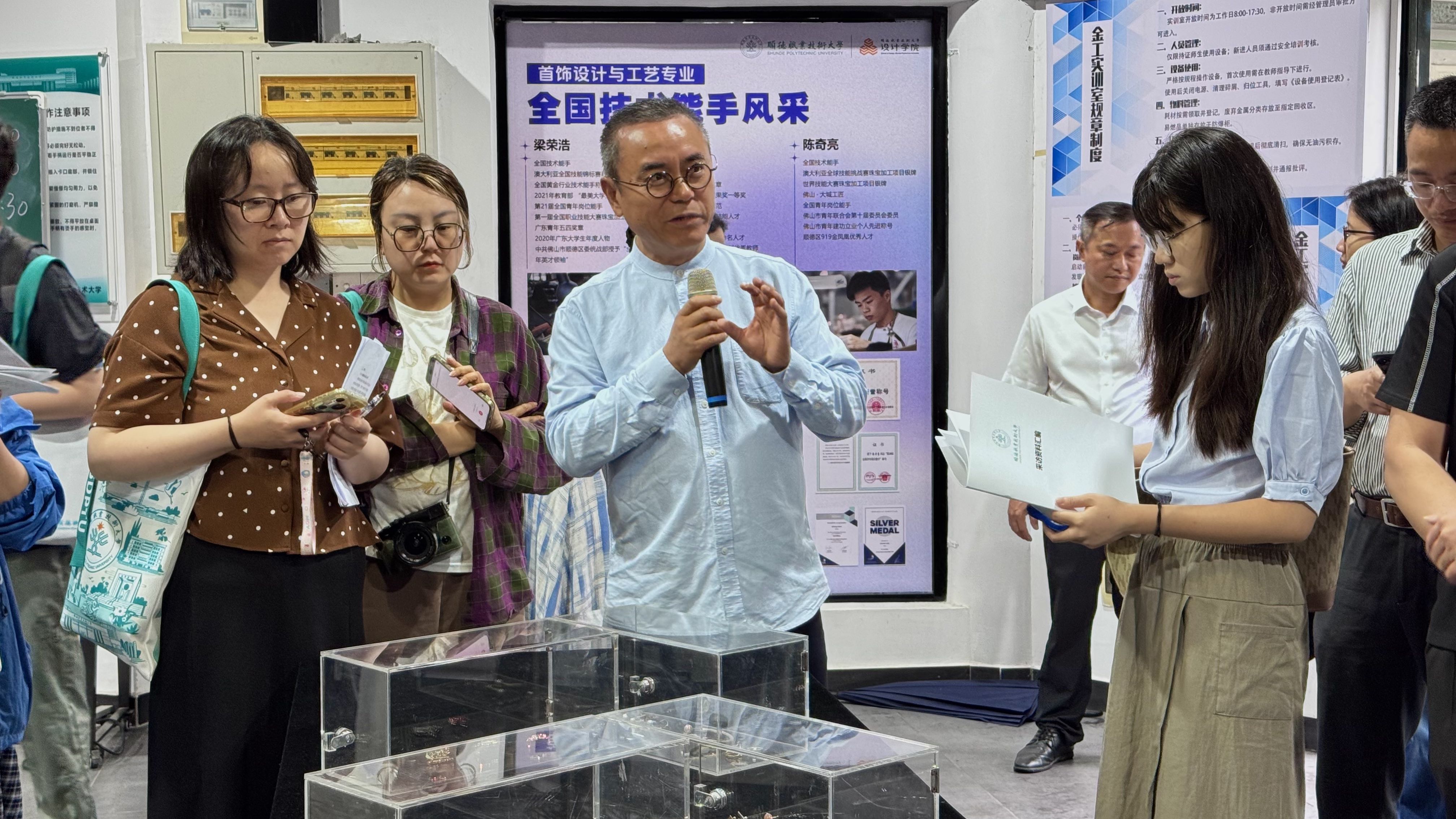 顺德职业技术大学设计学院相关负责人正向记者介绍展柜作品。人民网记者 李昊洋摄