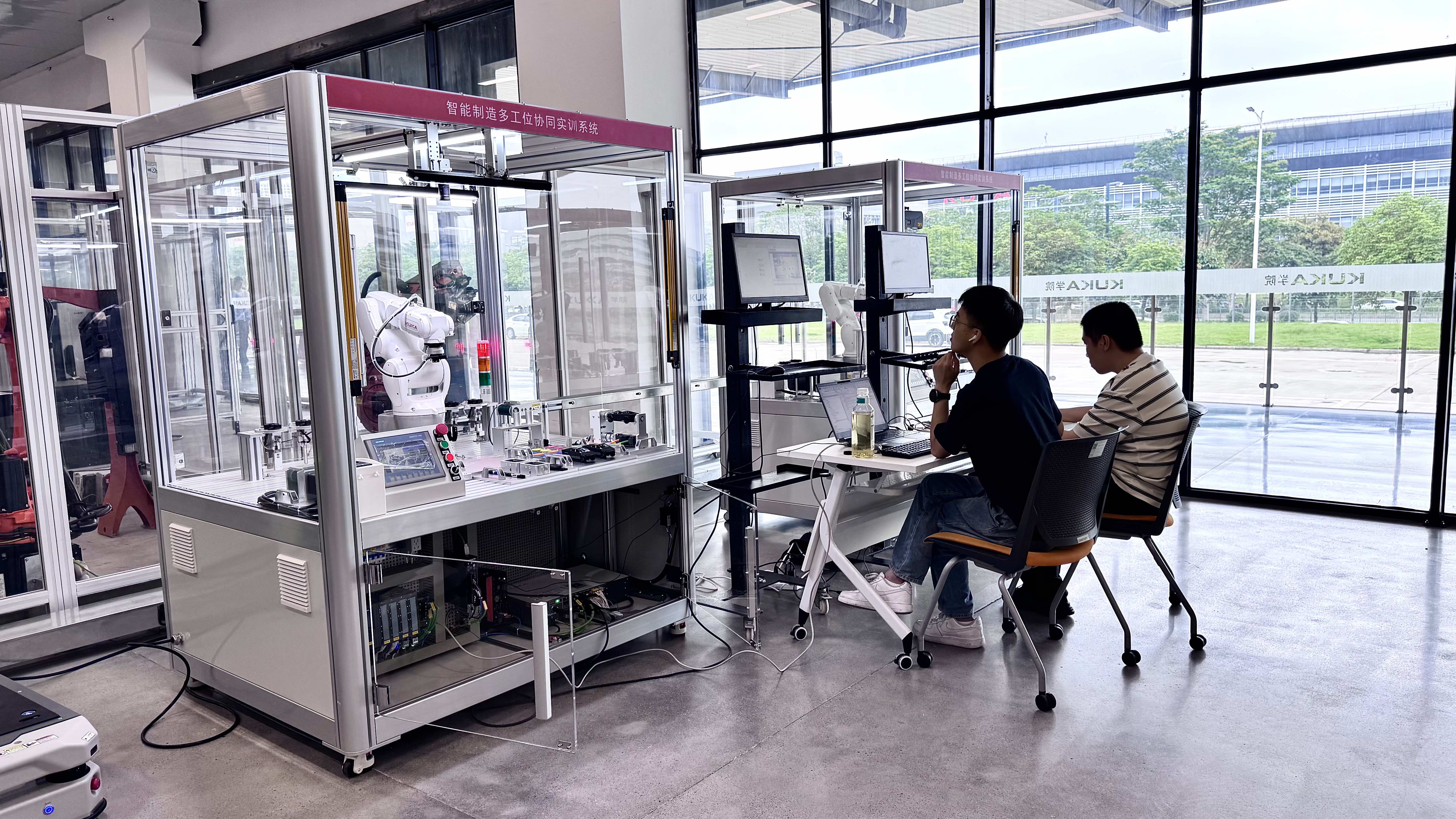 在库卡学院的智能制造实训室内，学员正在对实训系统进行调试与编程操作。人民网记者 李昊洋摄