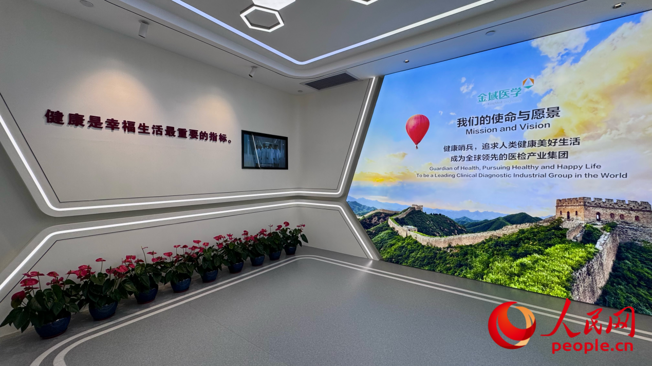 金域医学展厅内，“健康是幸福生活最重要的指标” 标语与企业使命愿景墙交相辉映，彰显守护全民健康的初心。人民网记者 李昊洋摄