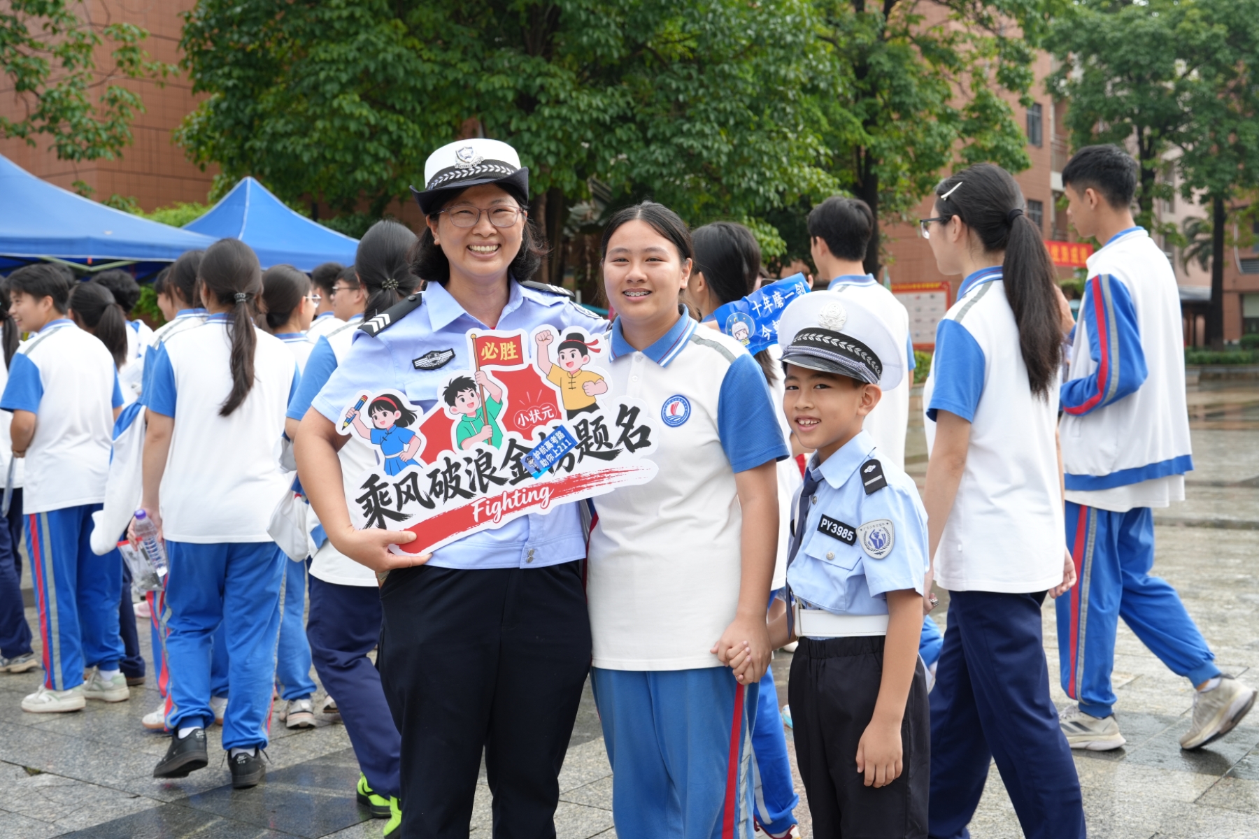 图为东莞市企石镇辅警黄玫宁在考场外值守时，与考生女儿和儿子合影。东莞市公安局供图