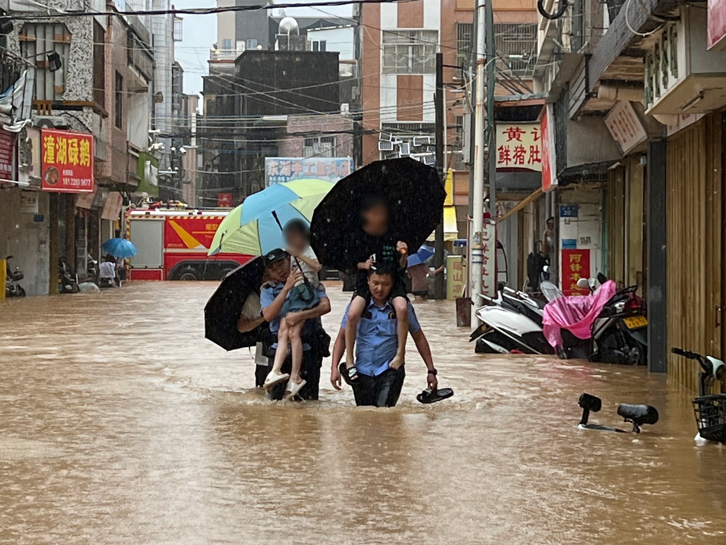 受强降雨影响，揭阳市惠来县多处内涝，公安民辅警转移被困小孩。揭阳市公安局供图