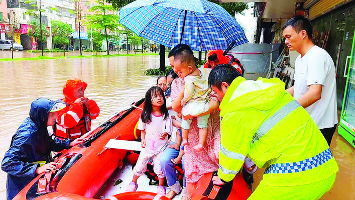 台风“红霞”带来强降雨，惠阳区秋宝路秋南医院路段严重积水，惠州市公安局惠阳分局交管大队民辅警蹚入齐膝深的水中，用冲锋舟营救被困的3名大人和4名小孩。惠州日报记者黄尉宏 通讯员宋彩霞 摄