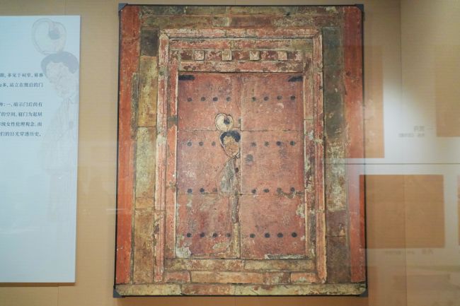 《妇人启门图》 壁画复制品，半掩门扉探身的妇人形象，折射古代女性的生活空间与传统伦理。人民网 李舜摄