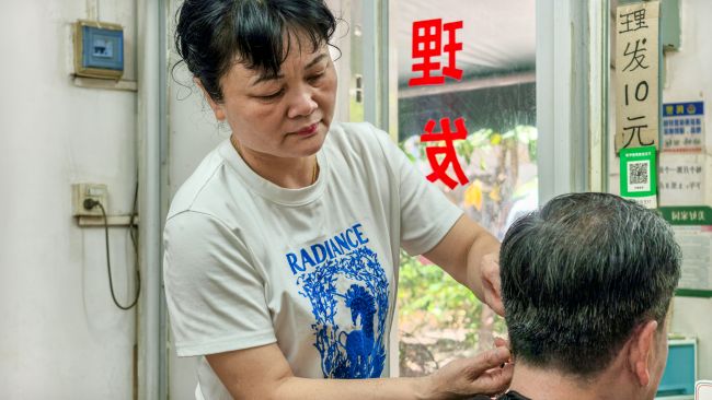 韦素梅在为居民理发。李文博摄